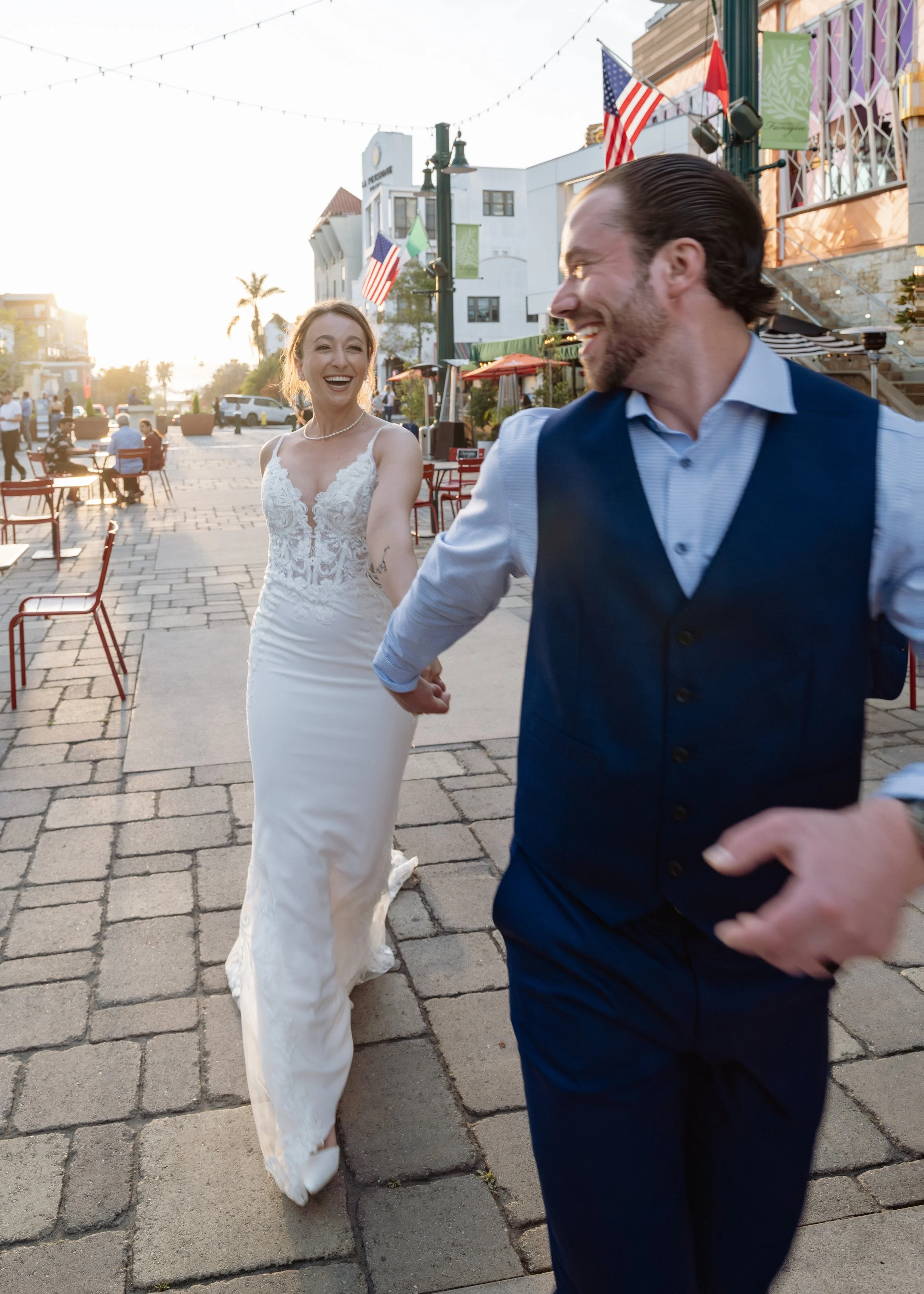 Elopement couple running down the street in Little Italy, San Diego — fun wedding day photography