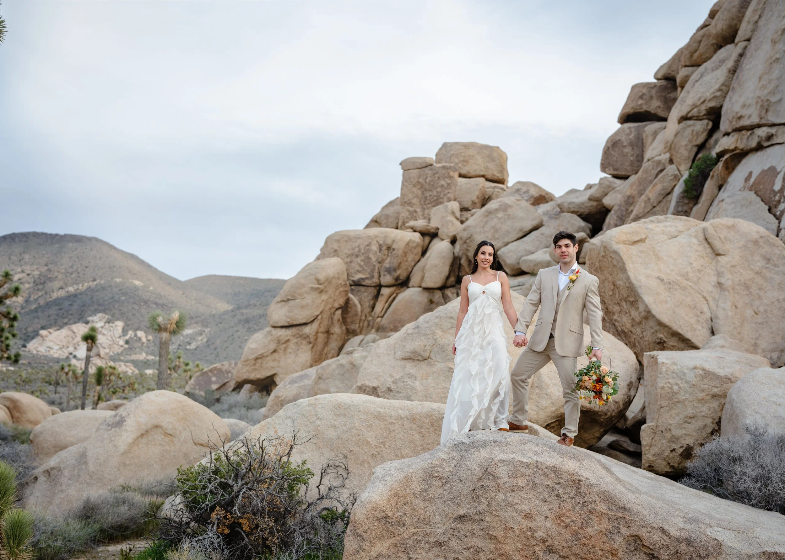 "Couple standing on boulders at Joshua Tree National Park elopement"