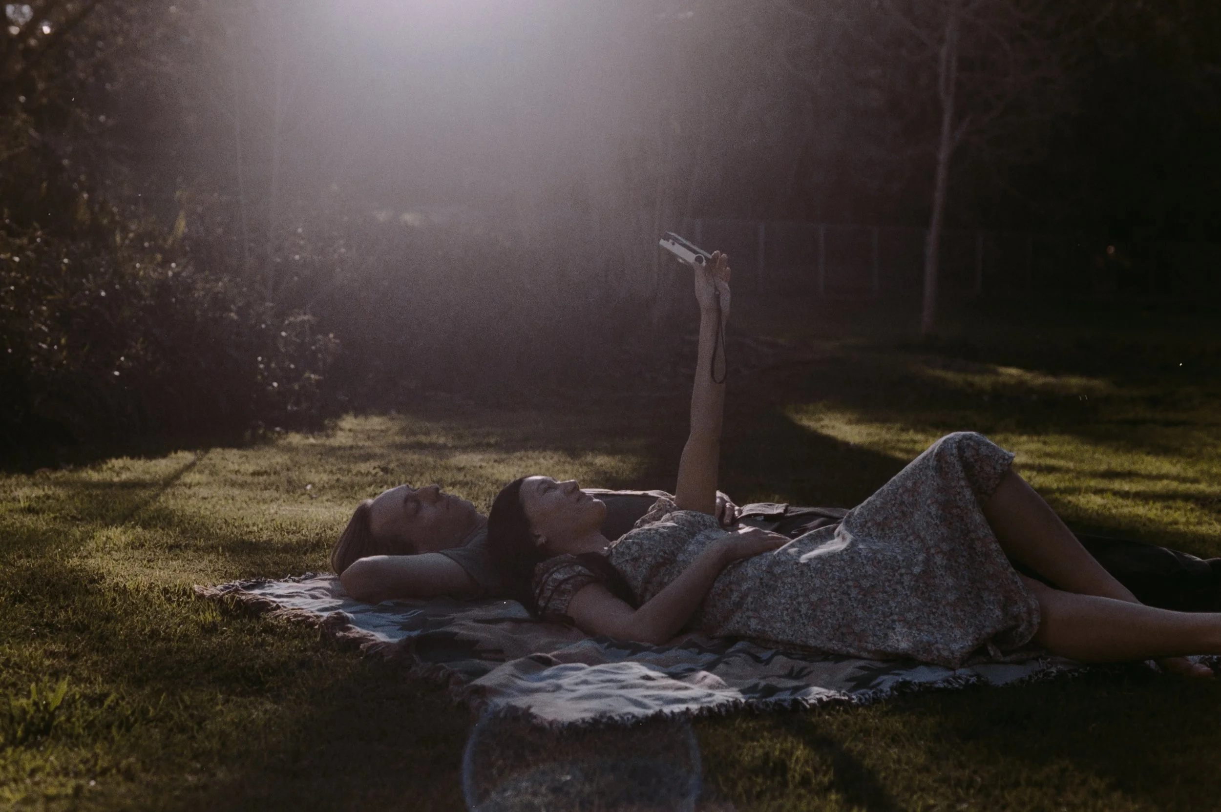 35mm film- Engagement session - couple laying on a blanket taking a selfie