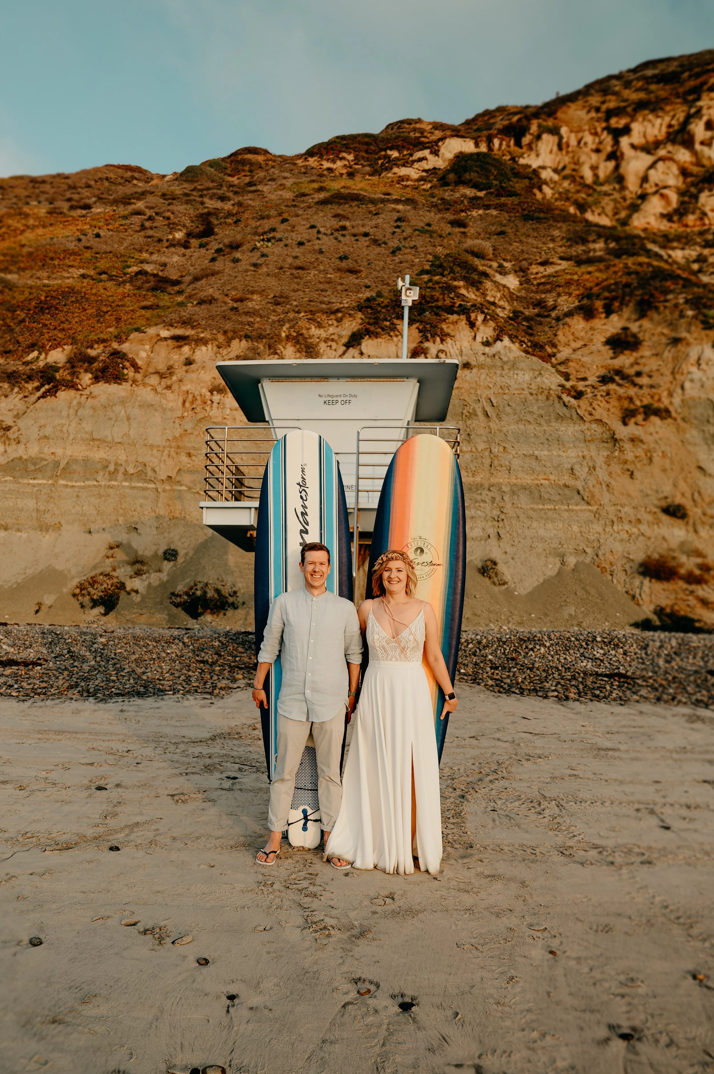 Torrey Pines elopement photographer San Diego — couple with their surfboards on the beach below the Pacific Cliffs, Torrey Pines State Natural Reserve
