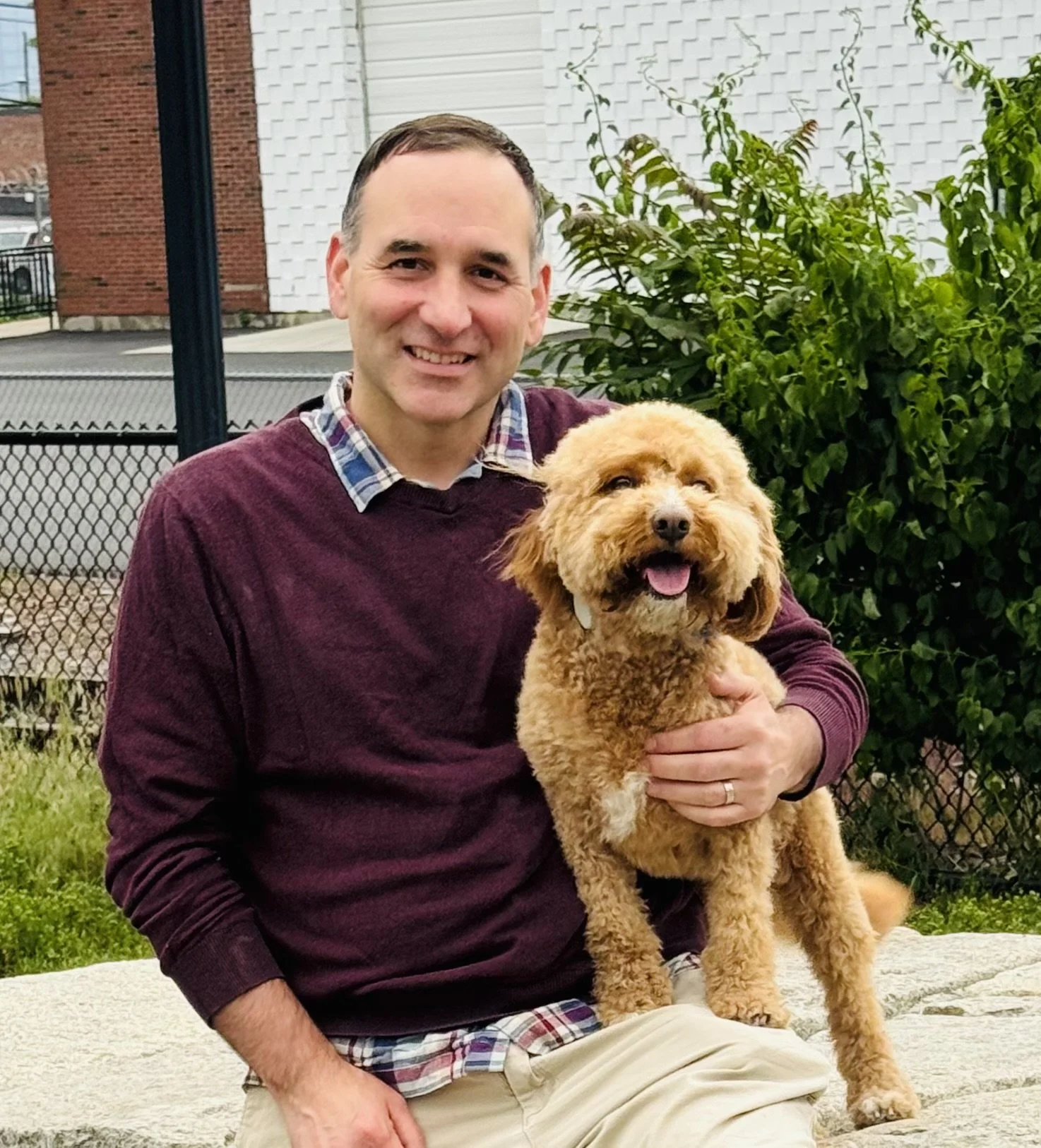 Jesse Clingan sitting outside with his dog.