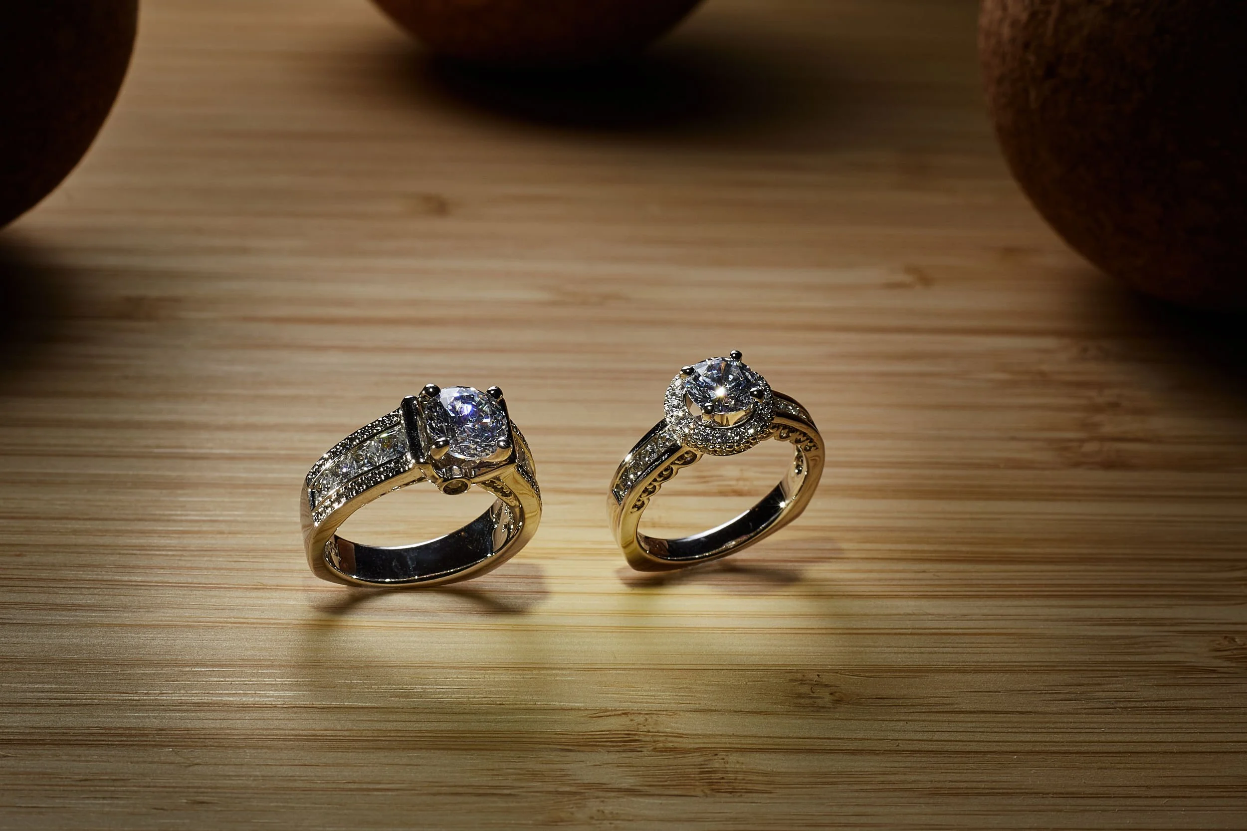 the wto rings on a natural plate made of bamoo and with cork in the background brings out the pure center stone from this lewlery captured by torsten glaenzel profeesional photography