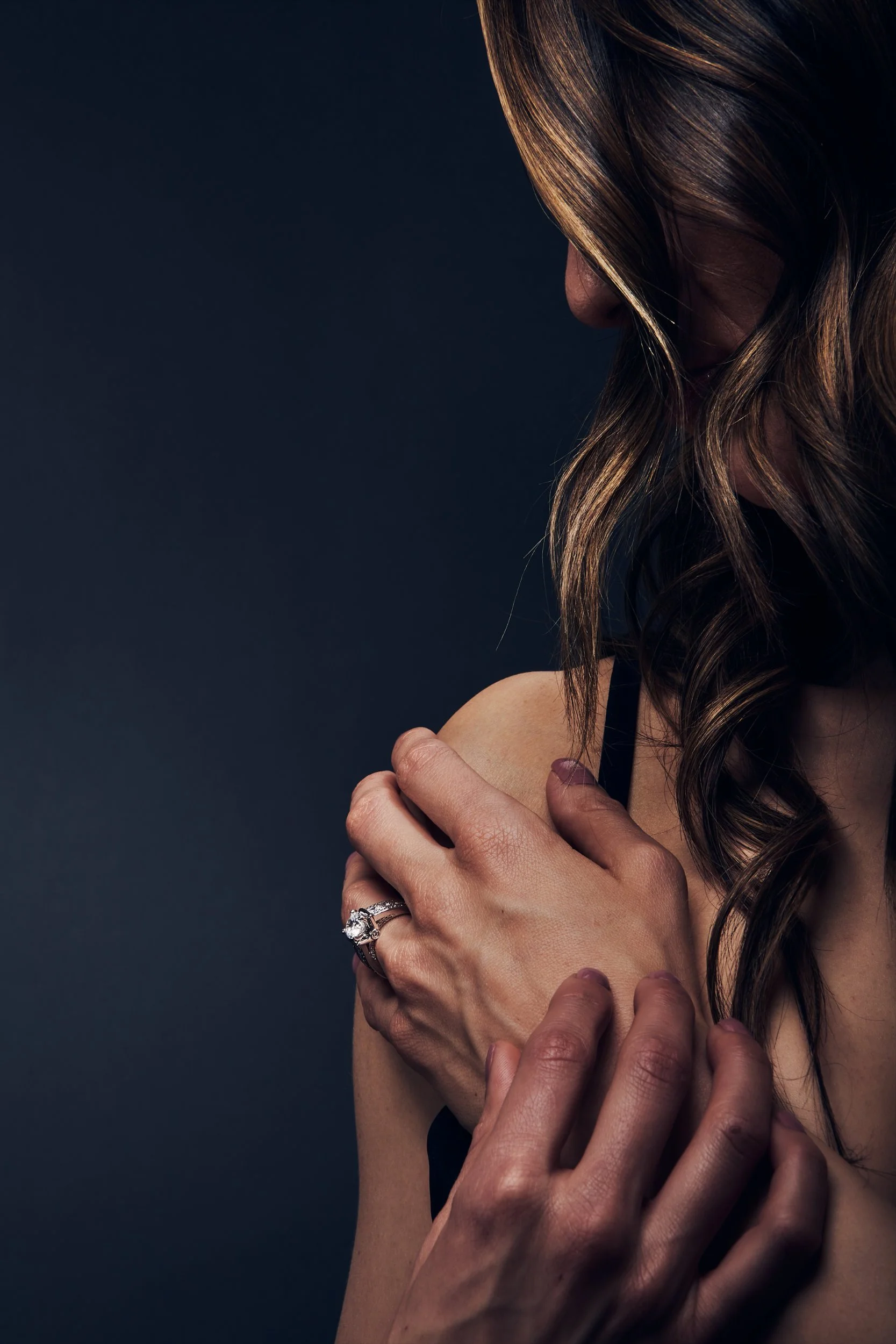 a woman with her hand on the sholder when the model shows of the beautiful ring on her finger while the long hair is down her neck by torsten glaenzel professional photography