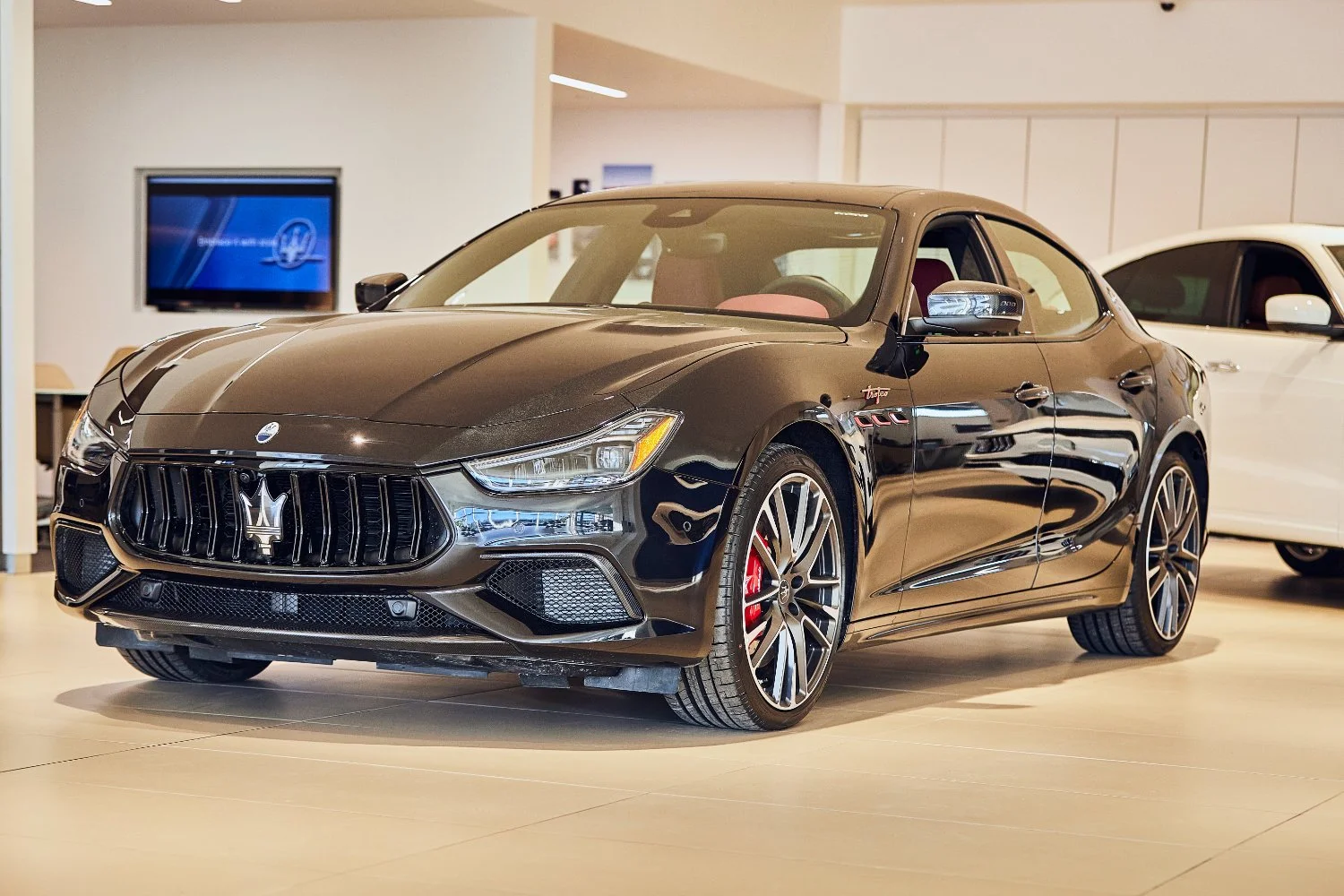 Maserati in black with huge horsepower and speed under the hood let the tires spinning luxury car in the dealership morries in minneapolis in the showroom taken by commercial photographer torsten glaenzel
