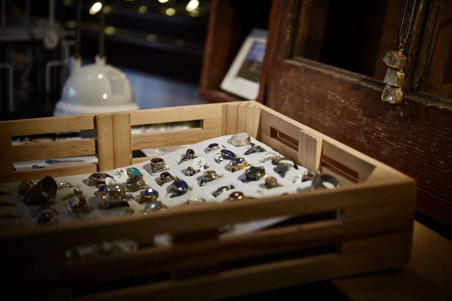 jewelry and a great gift made by local artists in Minnesota to see at the gallery fleur de lis in downtown Faribault commercial photography by torsten glaenzel with bright light in a wooden crate