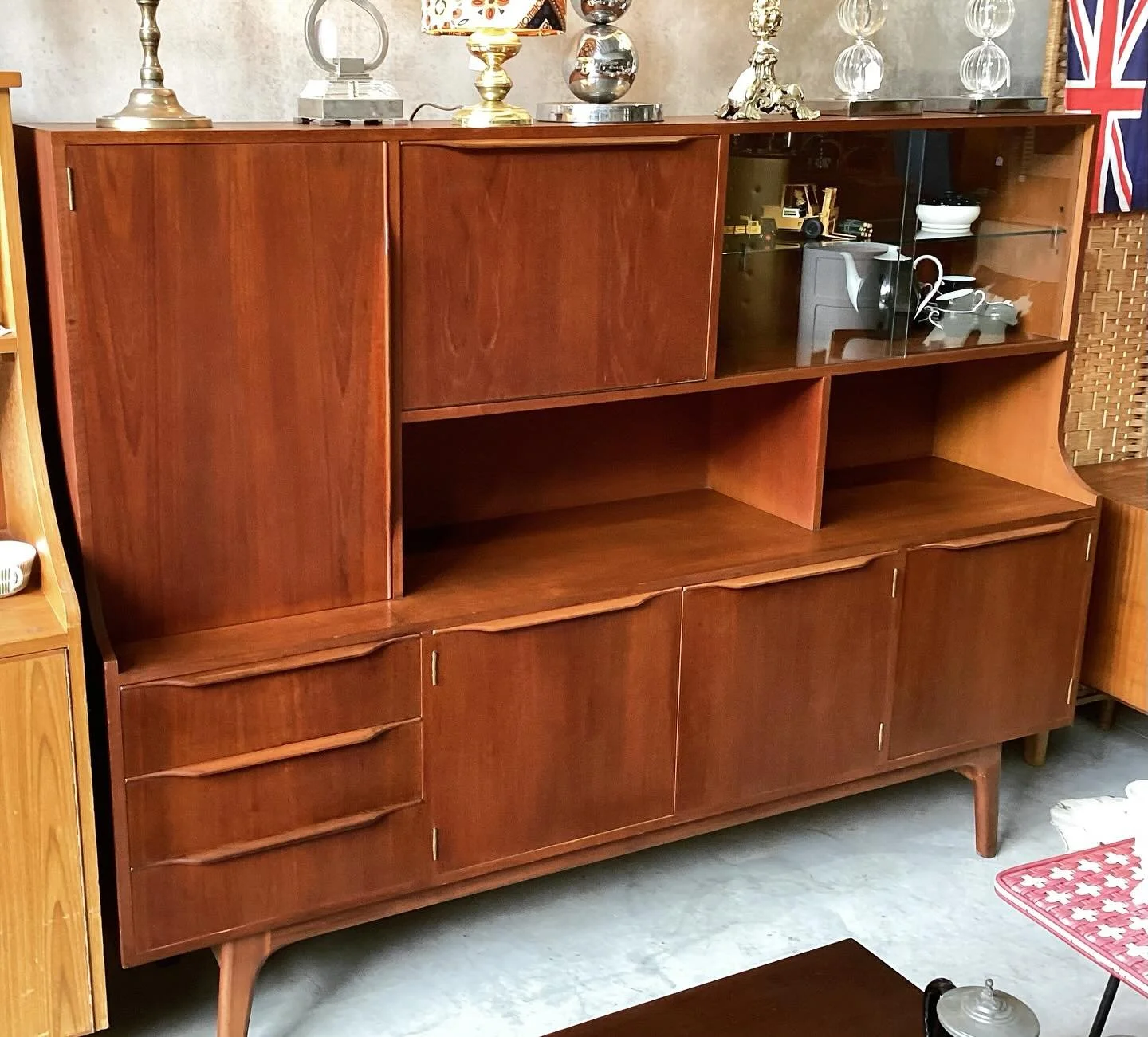 Mid Century High Board 

4 storage cupboards with adjustable shelves, 3 wave handled drawers (felt lined cutlery drawer) drop down cocktail bar and display cabinet with sliding glass doors 
Fantastic storage, 1.4 m of vinyl storage

180cm wide 
41cm 
