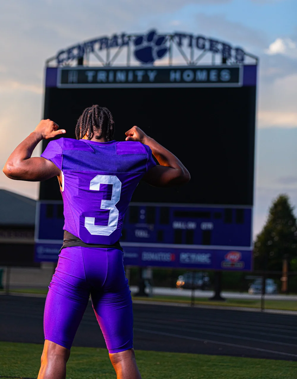 Football senior showing jersey number at the stadium scoreboard