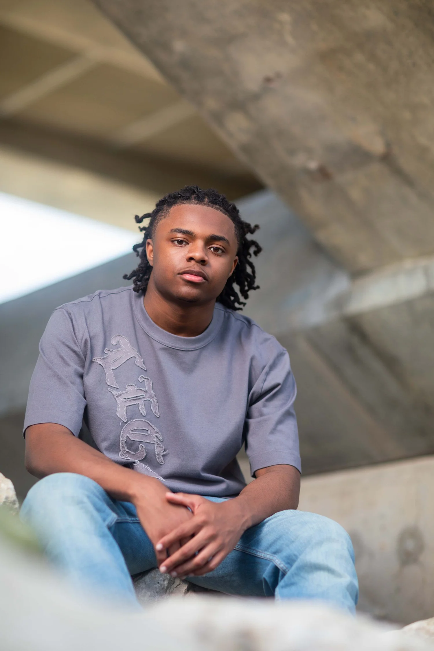 Moody senior portrait under a concrete bridge