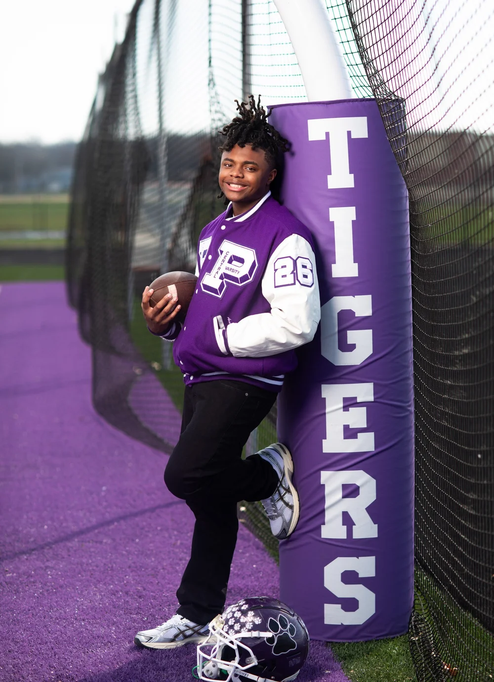 Senior in letterman jacket by the Tigers goal post