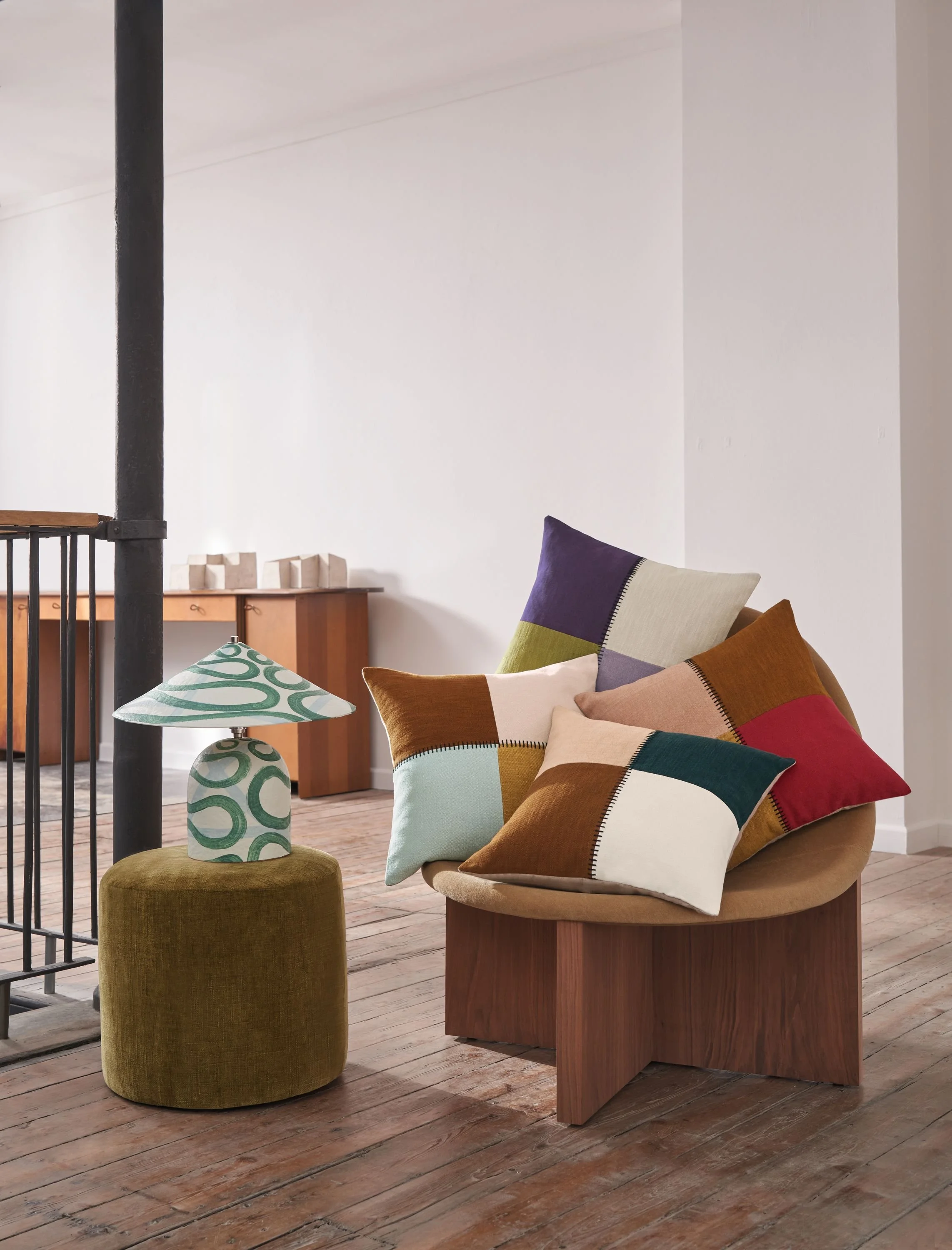 Maison Casamance Centon patchwork cushions, made from Paris Texas fabric, on chairs in a bright room
