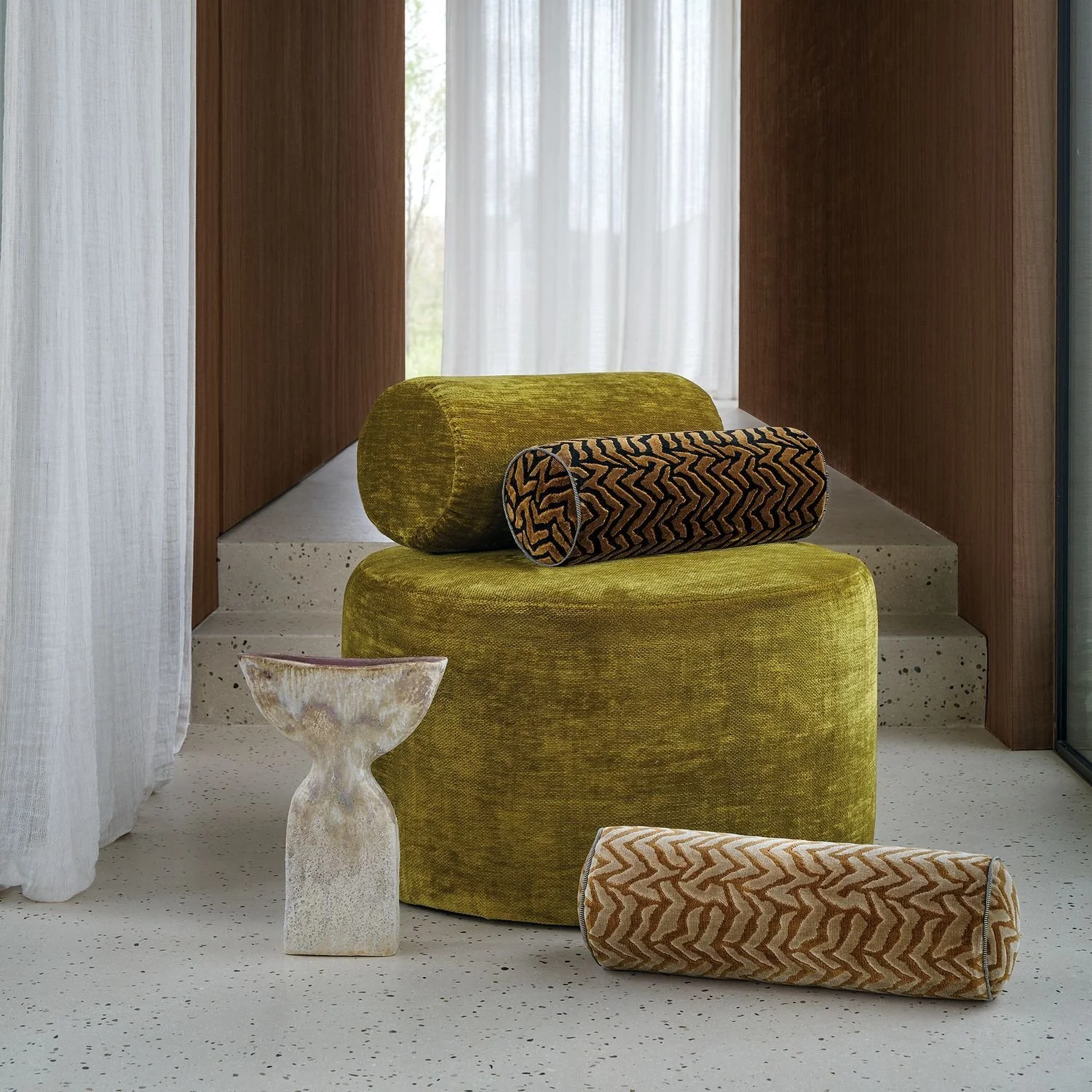 Maison Casamance Silhouette Ocre Noir bolster cushion in a room setting, wider view