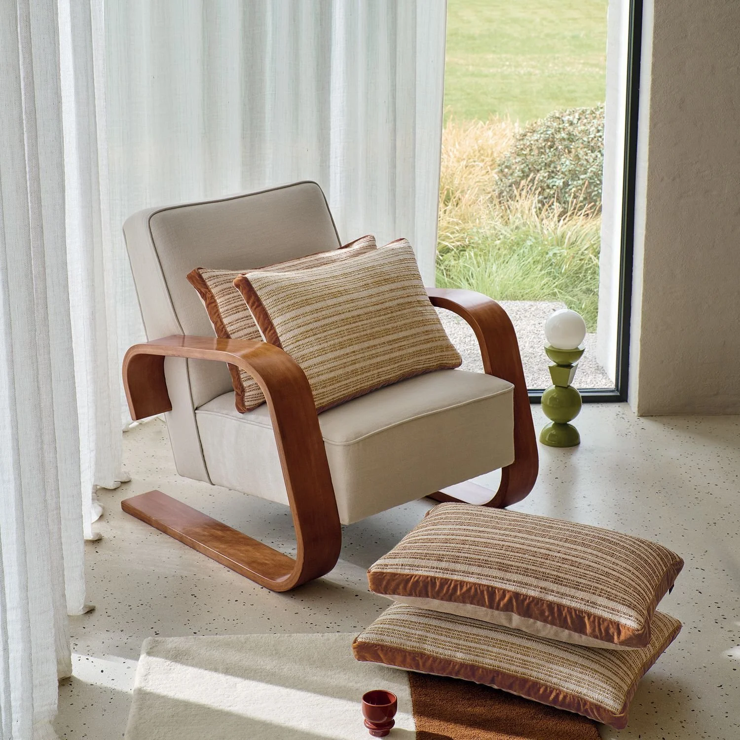 Maison Casamance Haute Lice Terracotta cushion in a room setting, wider view