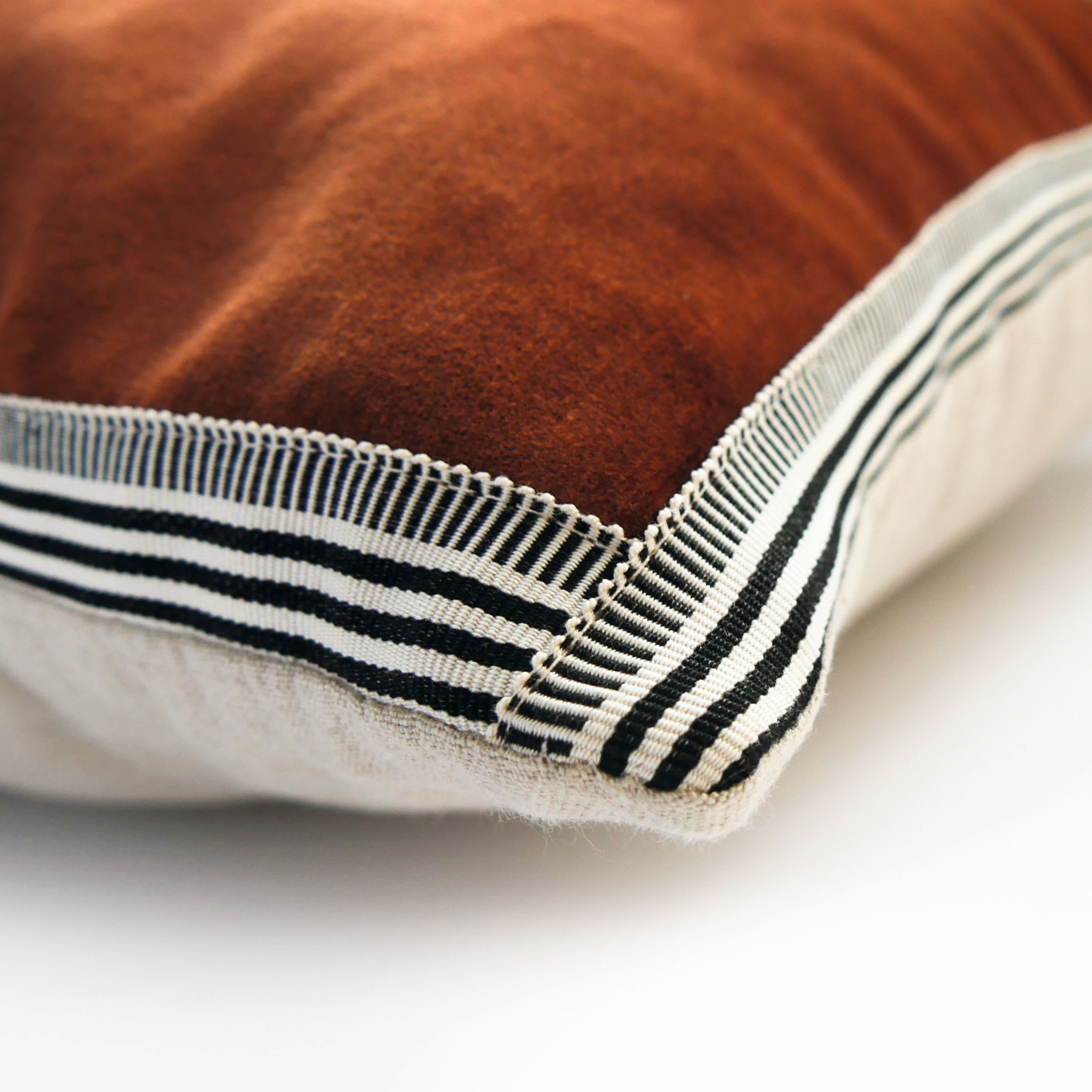 Close-up of the black and white braid edging on a Maison Casamance Manade velvet cushion