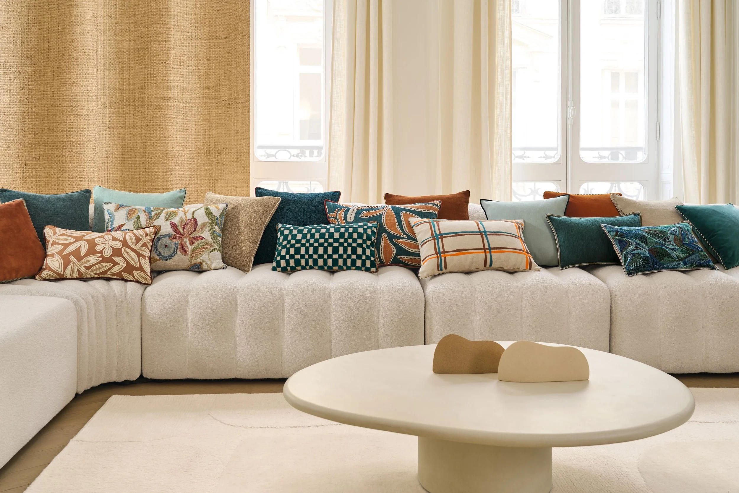 Cream sofa with Maison Casamance cushions in teal, aqua, marine blue and terracotta