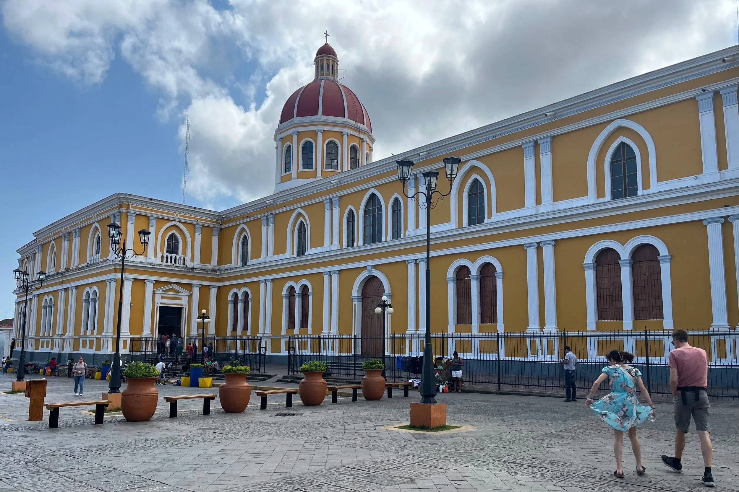 A yellow church with tourists walking outside, one of the top places to visit in Nicaragua