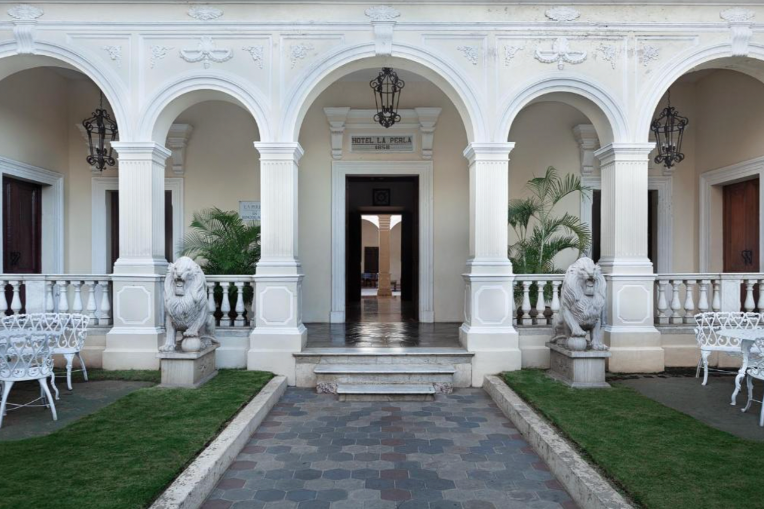 The entrance to Hotel La Perla Leon with white pillars and lions at front, one of the places to visit in Nicaragua