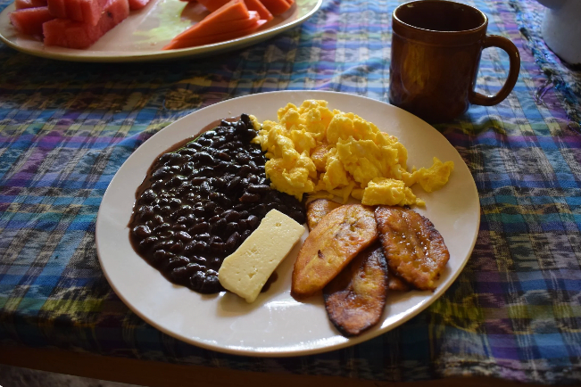 A hearty breakfast plate at Tuqtuquilal with eggs, beans, and plantains in Semuc Champey