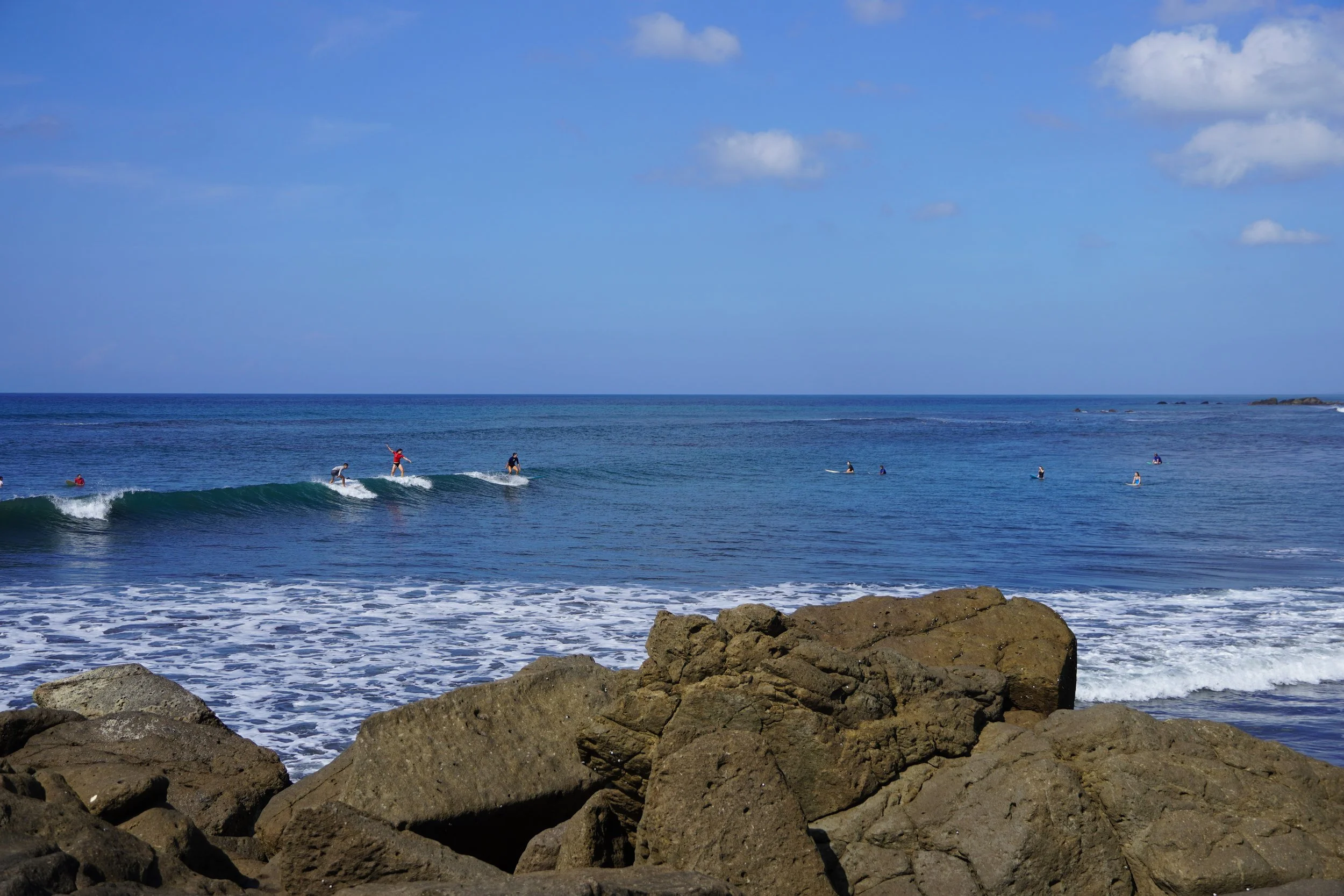 Surfers are riding a wave on the coast of Nicaragua