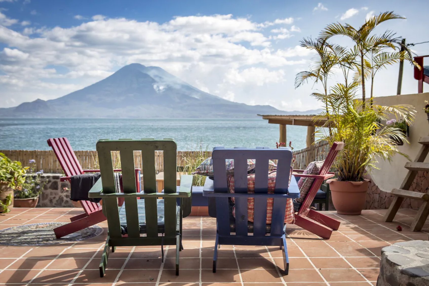 Lounge chairs sit outside looking at.a volcano at La Iguana Perdida, one of the best Lake Atitlan Hotels
