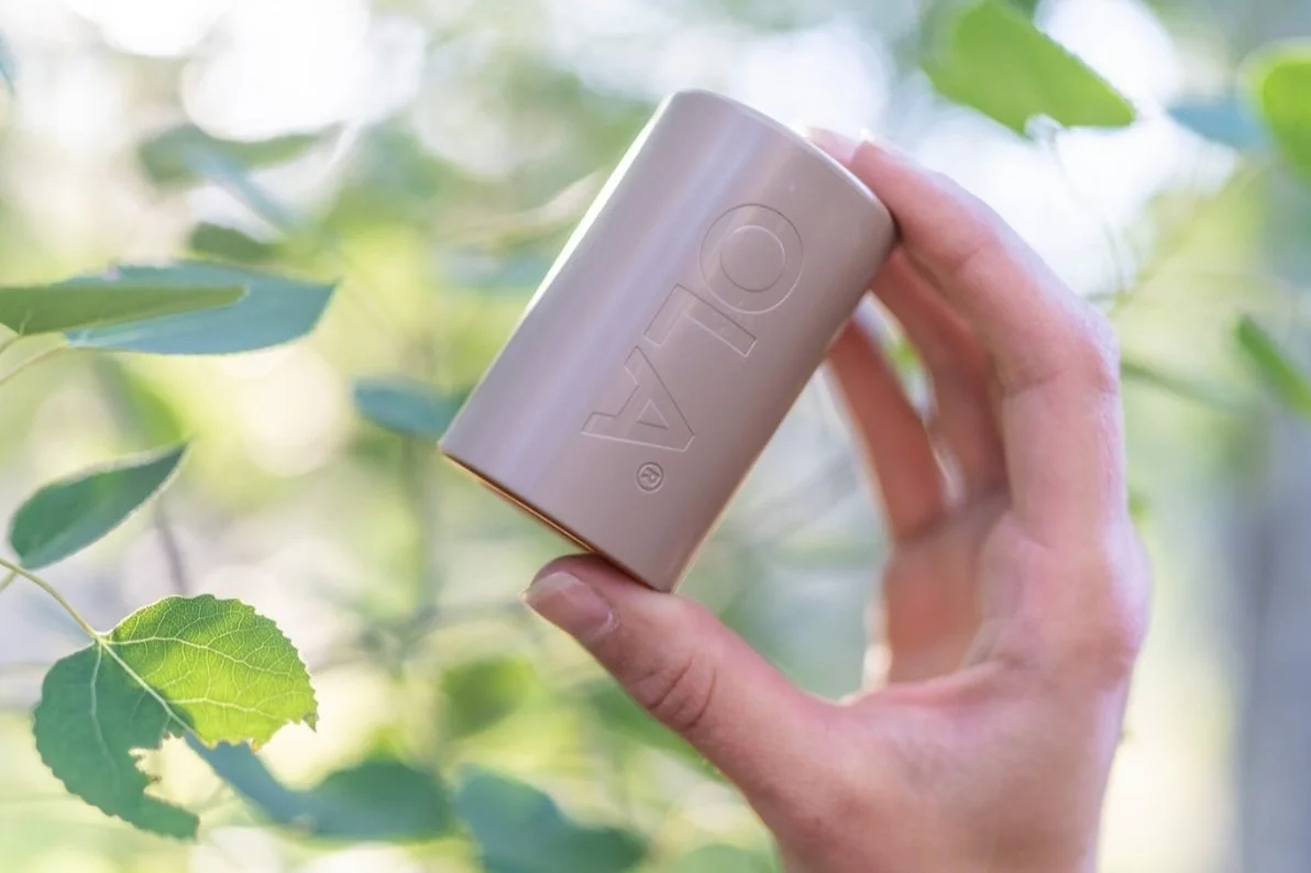 A person is holding up the Ola water filter, an organization you can donate to on Giving Tuesday