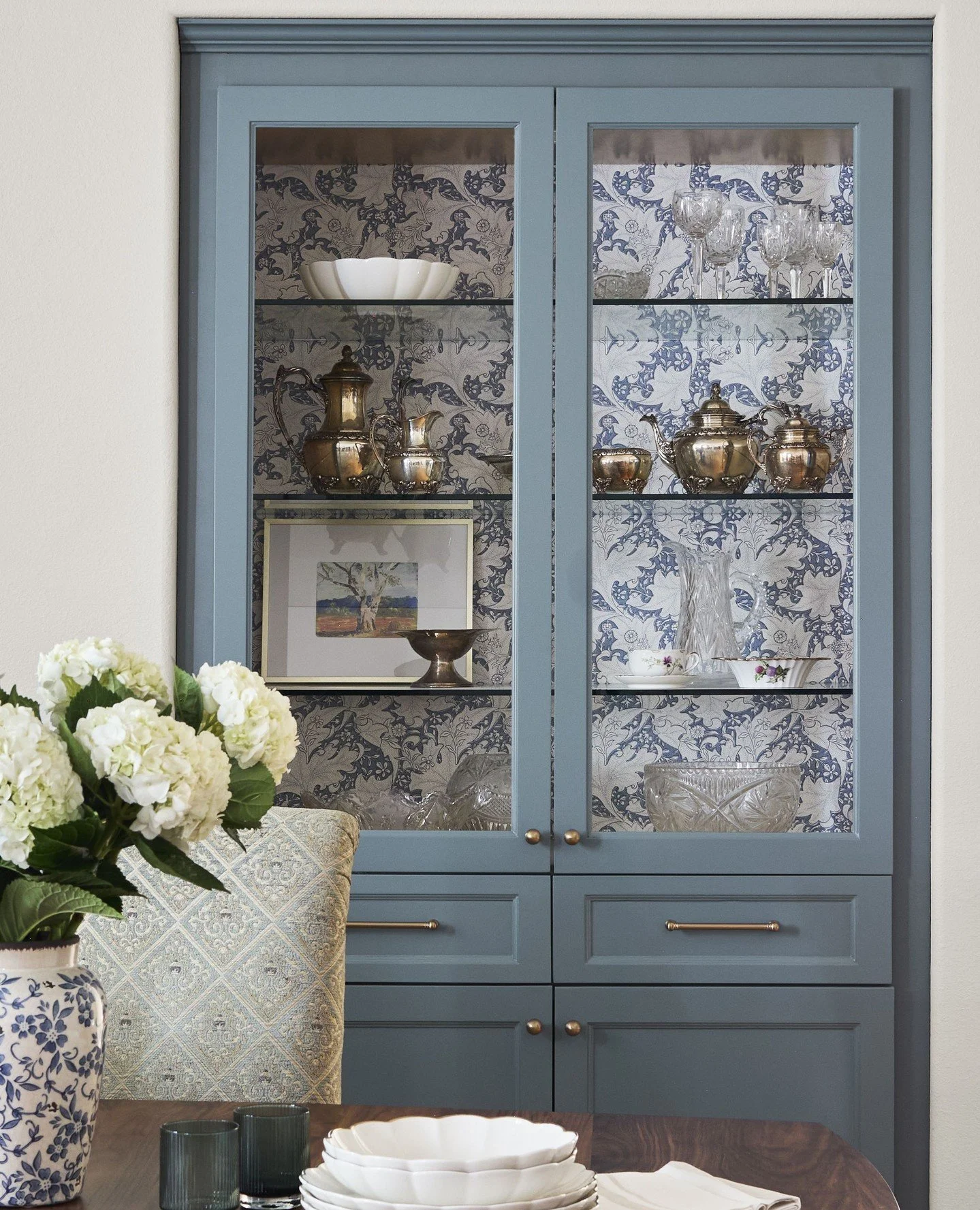 A cabinet moment worthy of its own spotlight 🤩⁠
⁠
Glass-front shelving, vintage-inspired pattern play, soft blue tones, and collected pieces come together to create a space that feels equal parts curated and cozy. Proof that storage can absolutely b