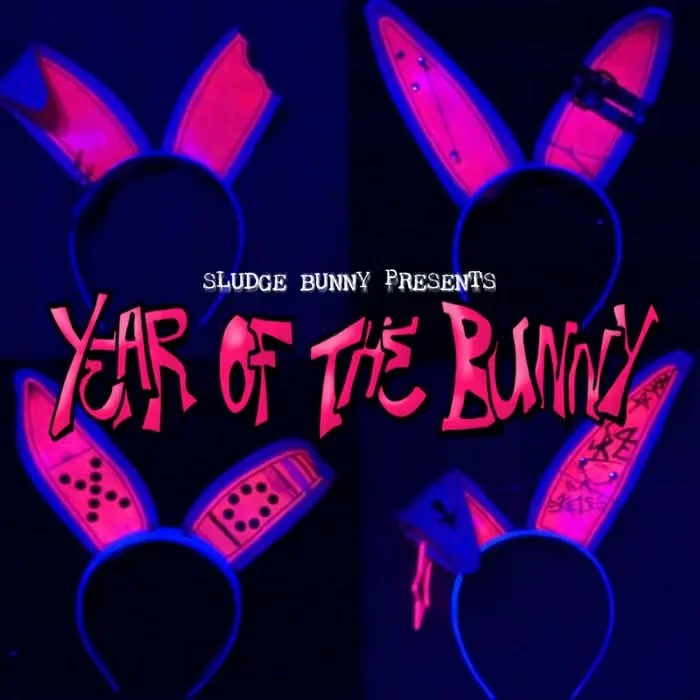Glow-in-the-dark headbands with bunny ears and decorated cards, with text 'Sludge Bunny Presents Year of the Bunny' on a dark background.
