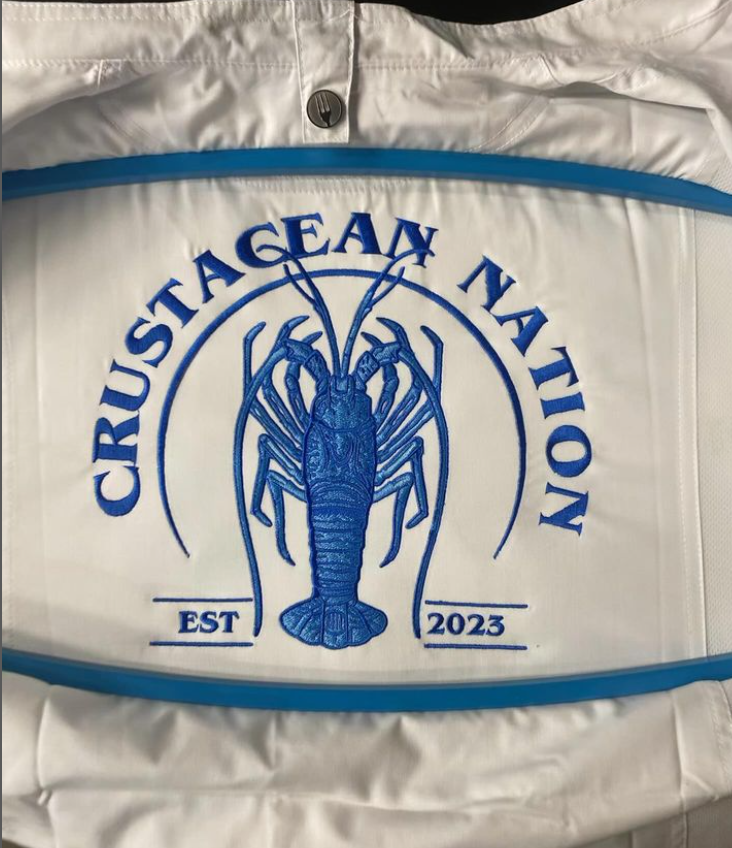 Crustacean Nation logo embroidered on a garment