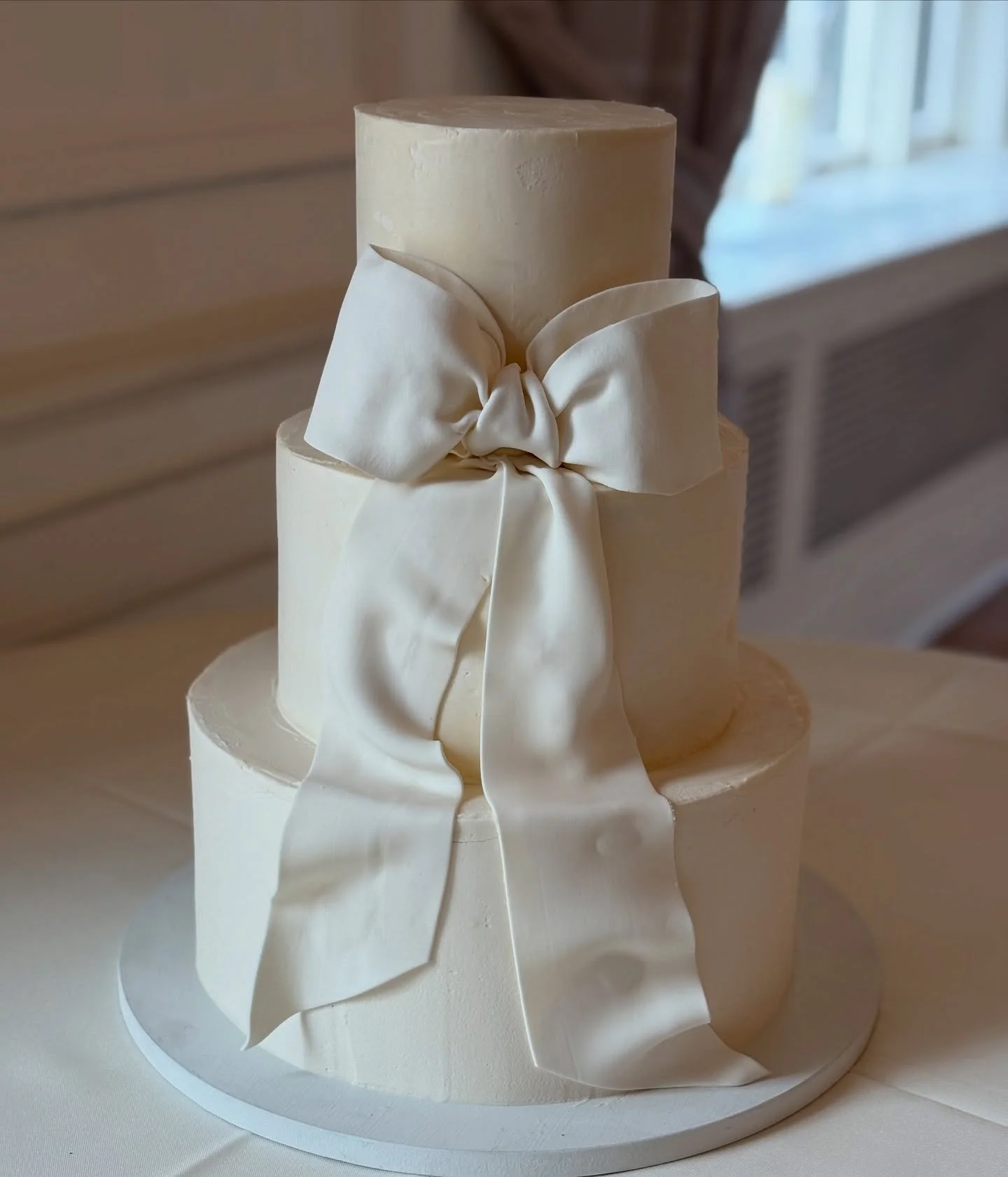 An elegant buttercream cake with fondant sugar bow.  #bellamanse#cakesnearme#lancasterpaweddings