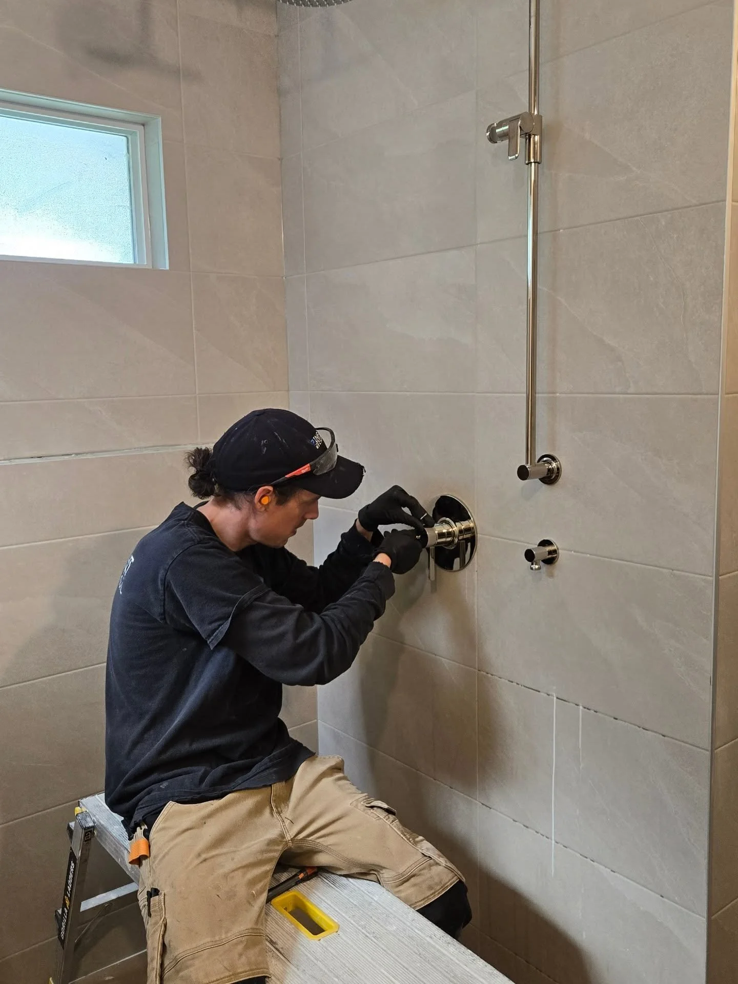 Our expert finisher Spencer, installing shower trims in this ensuite bathroom