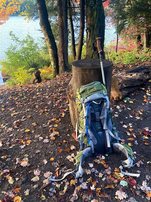 Backpacking backpack resting on a log. Mirror Lake in the Porcupine Mountains in the background.