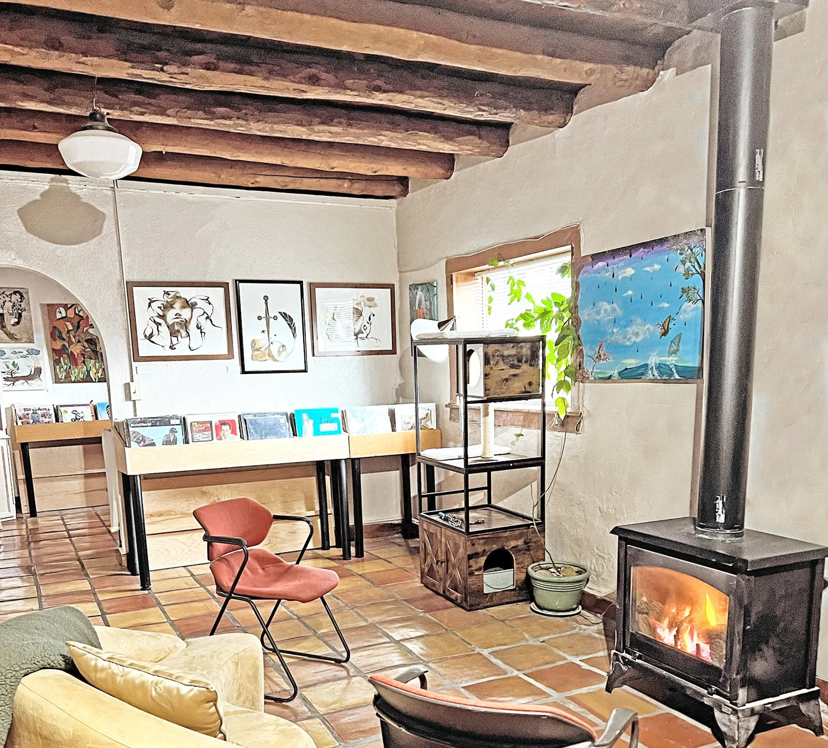 A 100 year old adobe home Santa Fe New Mexico retains its cozy, rustic living room as the art gallery of Linda Storm.