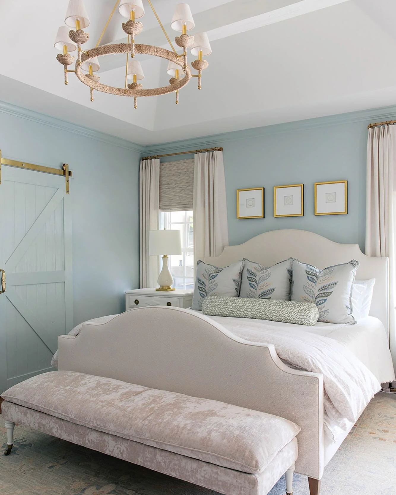 We layered the bed in this master bedroom with neutrals and soft blues and greens for the pillows, creating a space that will always feel timeless and inviting.