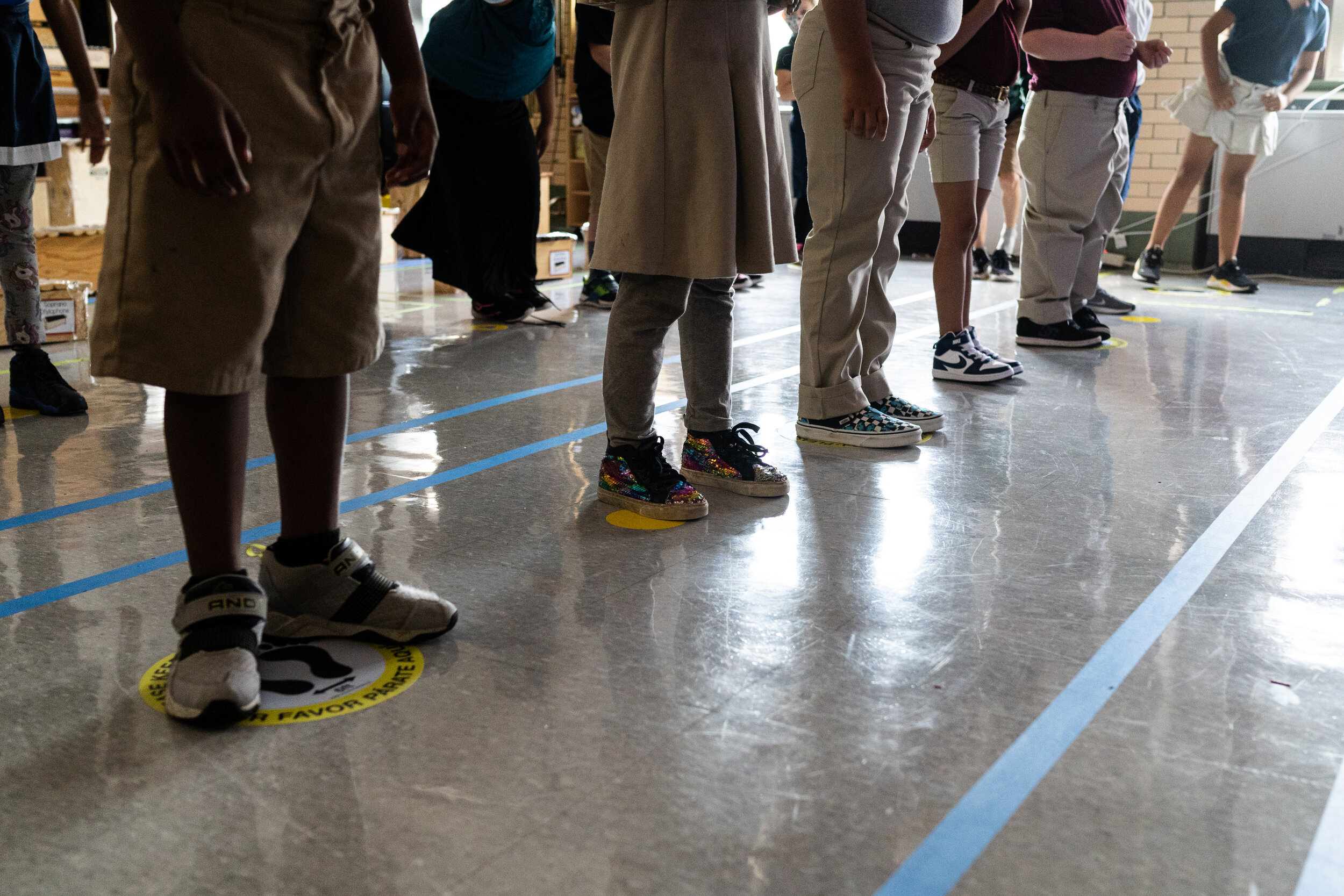 In order to keep them as separated as possible, students in Quesada's third grade class stand on carefully placed stickers on the floor. Because of the space instruments take up, and the need for students to be able to see their teacher, there's ofte