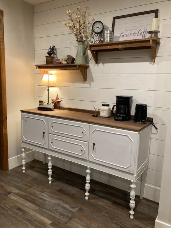 French country coffee bar made from solid oak with a black walnut top. This classic piece stands upon hand turned custom spindle legs and is accompanied by hand made bead trim and bead work. The client requested a more traditional antique appearance 