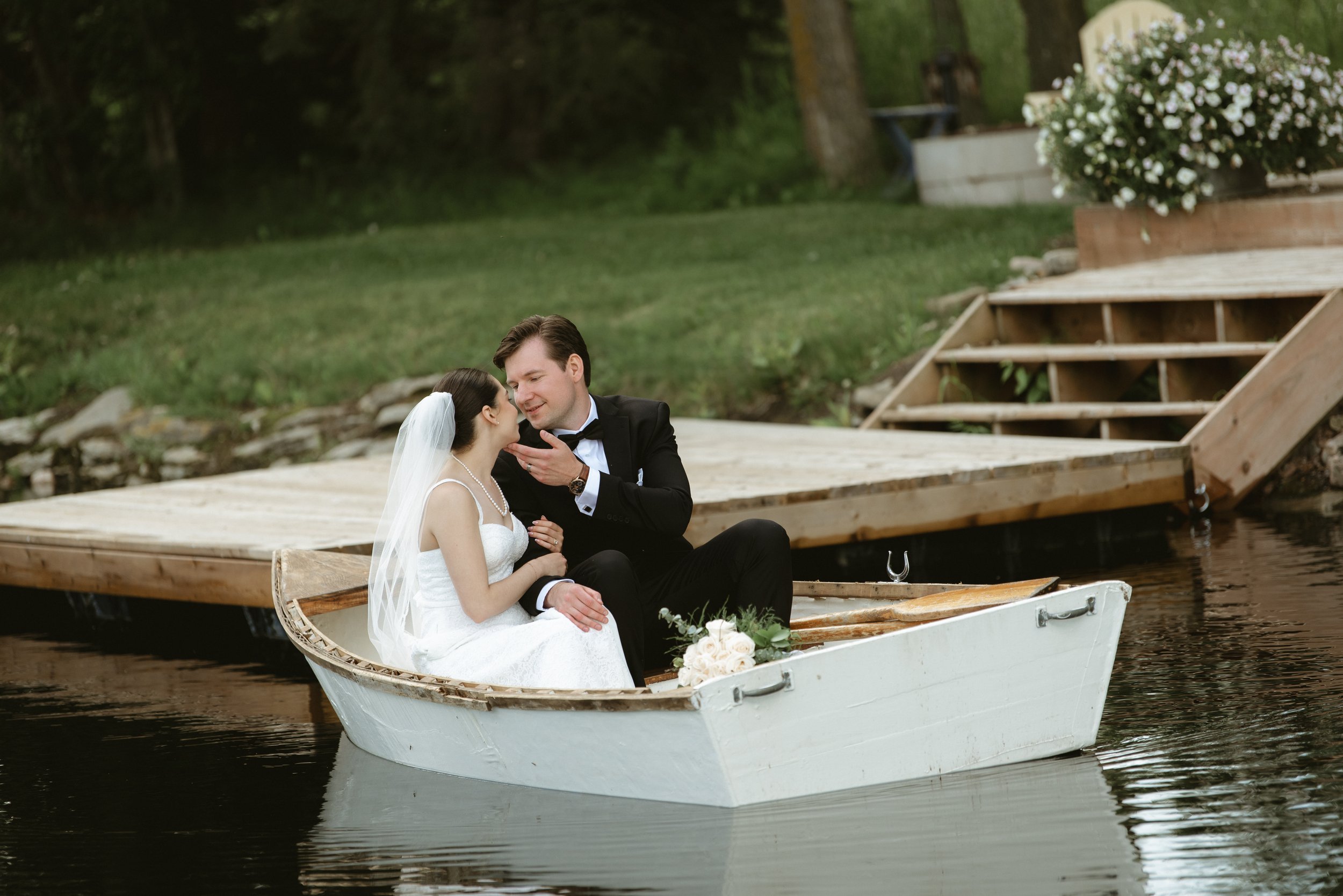 Bride and groom sharing a quiet moment in a row boat during their wedding at Pine & Pond Wedding Venue in Ponoka County, Alberta photographed by Danielle Aichelle Photography