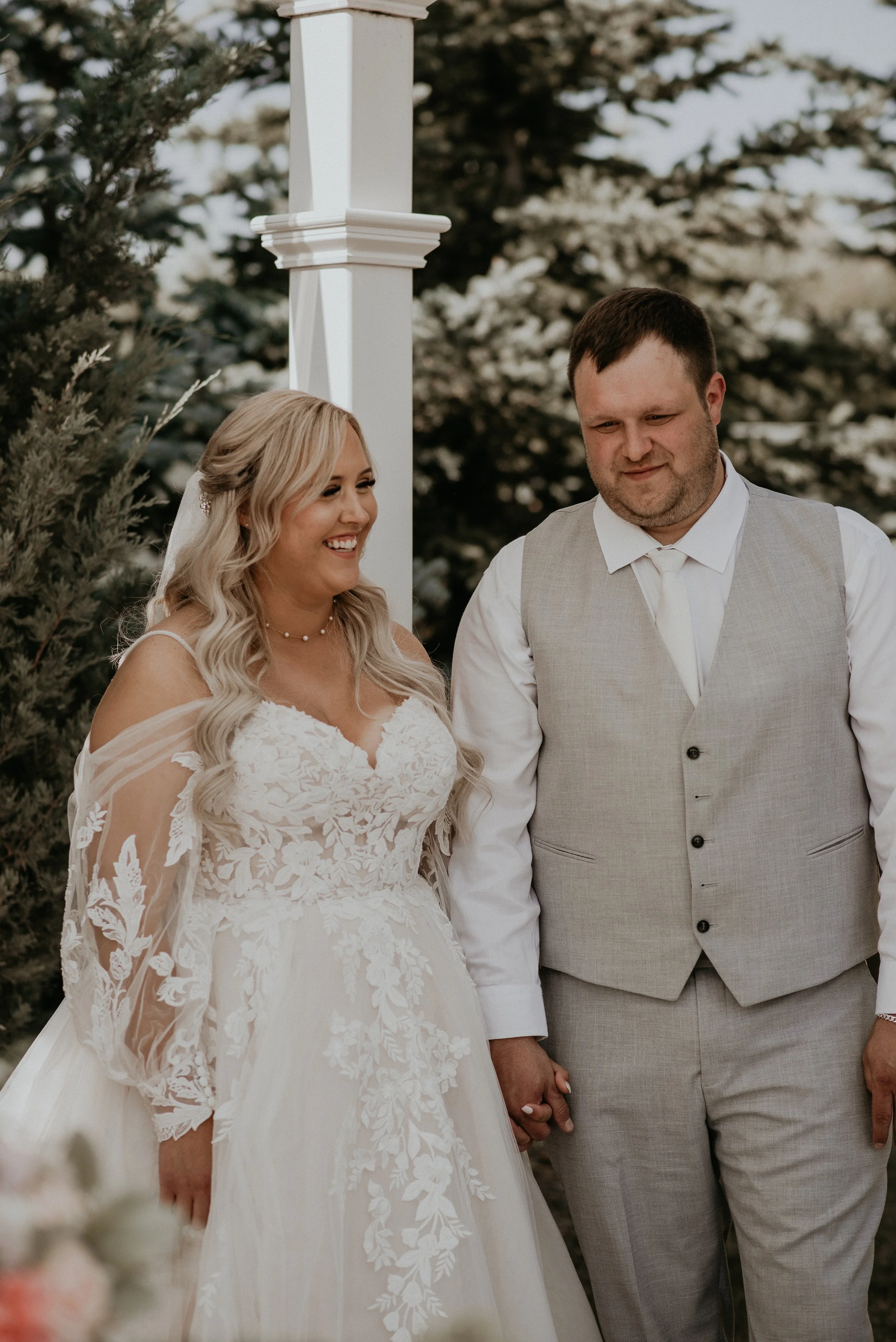 Bride and groom smiling together during their outdoor wedding ceremony in Red Deer Alberta