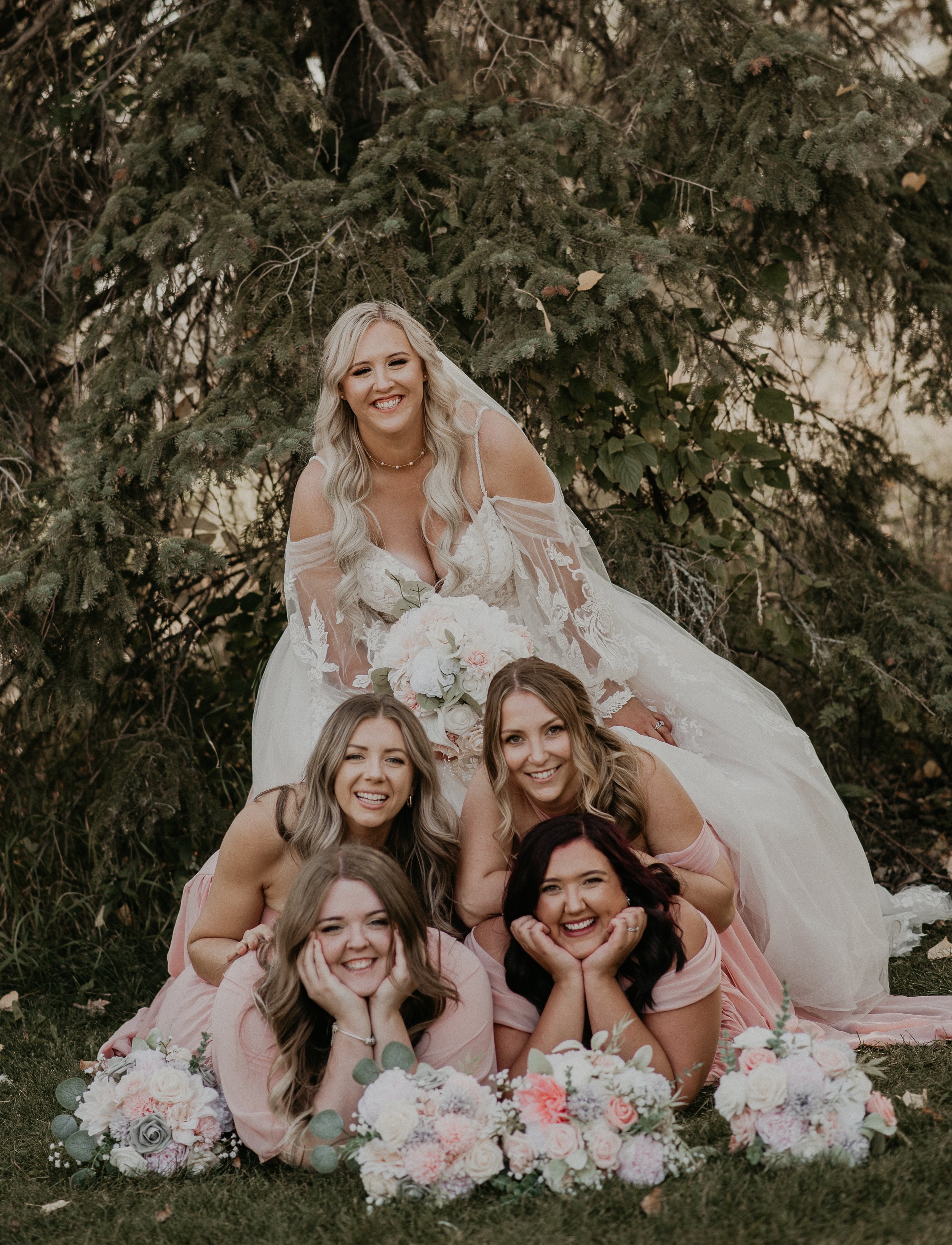 Bride laughing with her bridesmaids during relaxed wedding party portraits in Red Deer Alberta