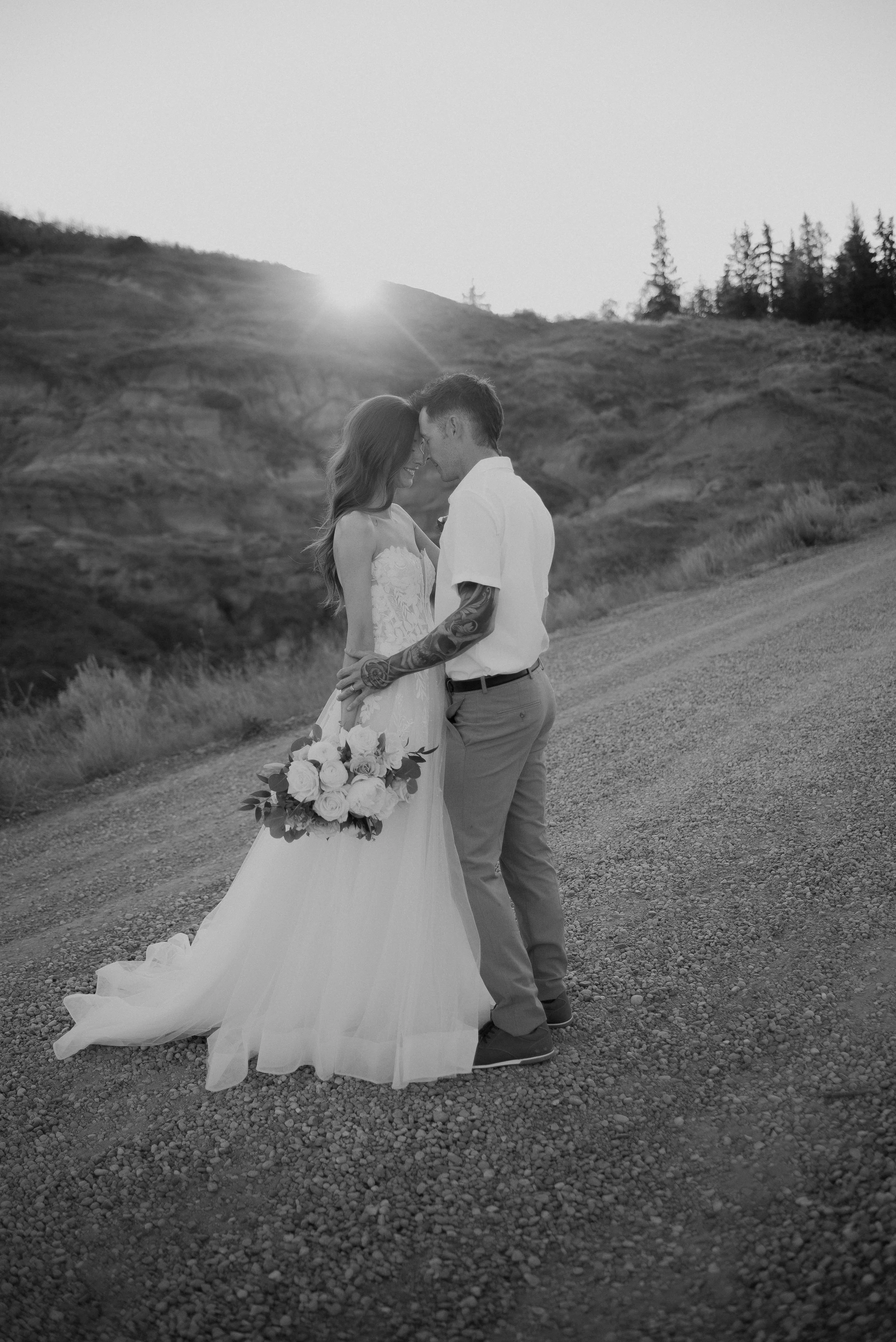 Bride and groom embracing at sunset during a romantic Drumheller elopement