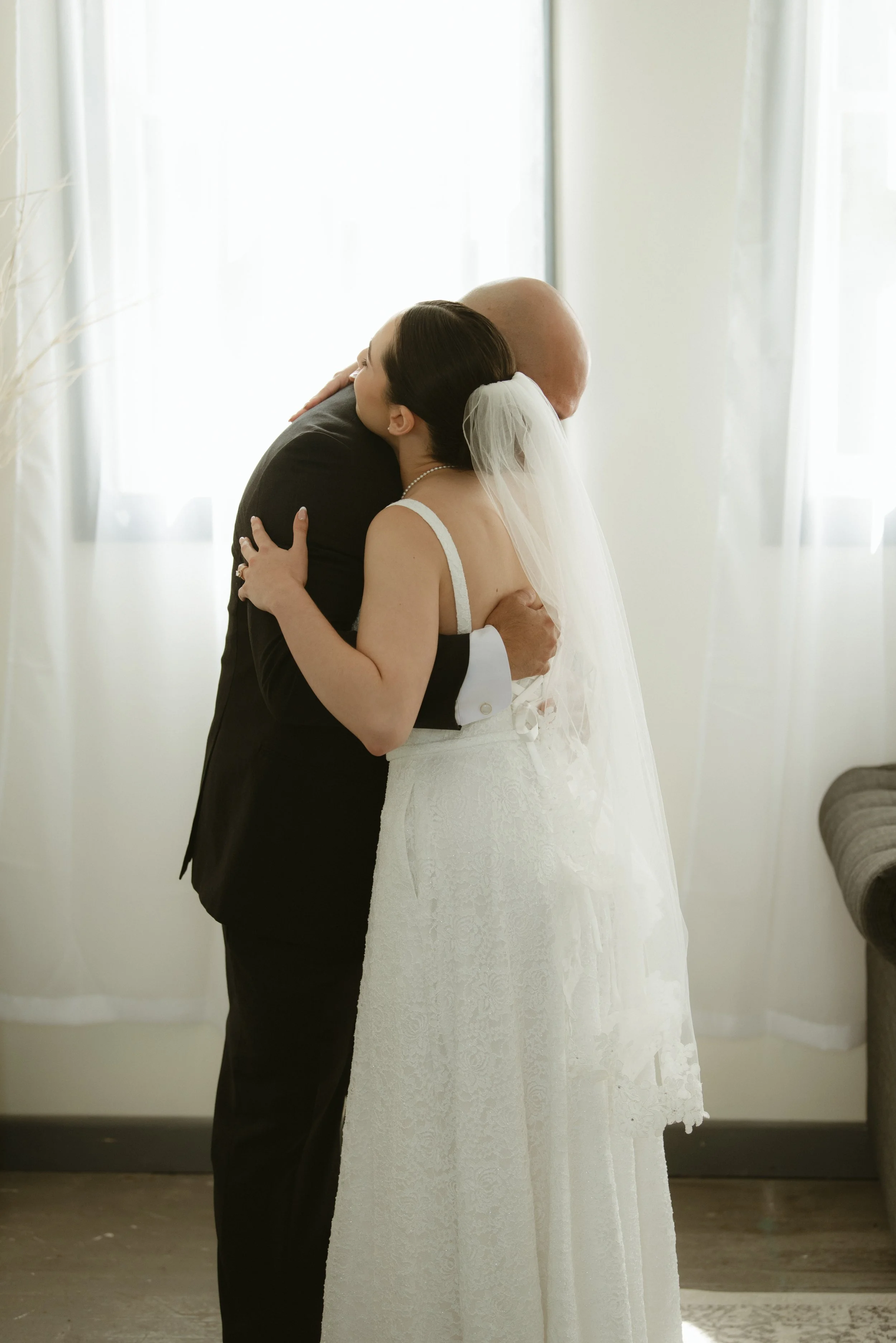 Bride embracing her father during an emotional first look before the wedding at Pine & Pond Wedding Venue in Ponoka County, Alberta, photographed by Danielle Aichelle Photography