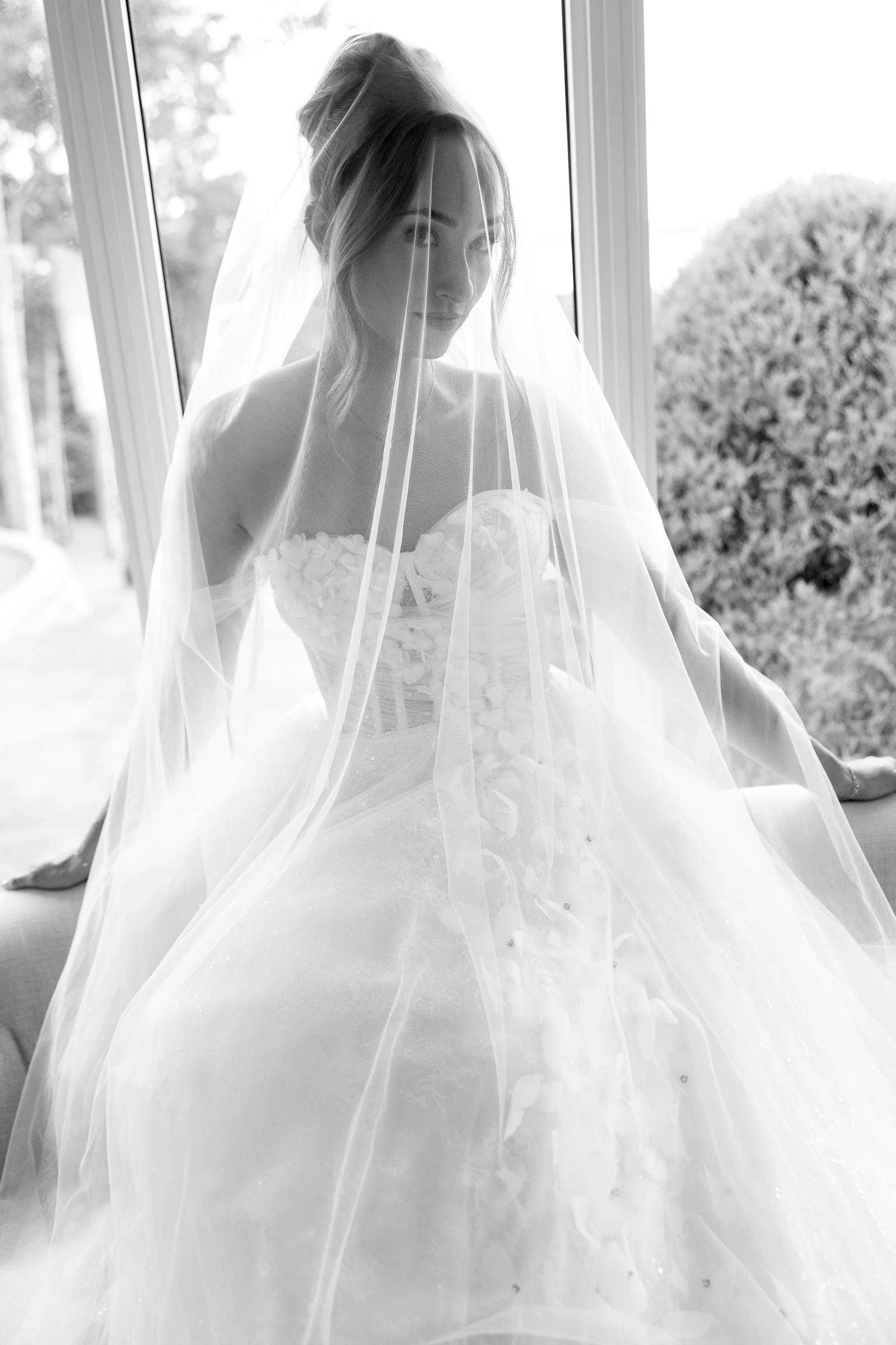 Bride wearing her wedding gown and veil with an elegant bridal updo, styled by Danielle Aichelle Artistry, at Hilltop Wedding Center in Sylvan Lake, Alberta