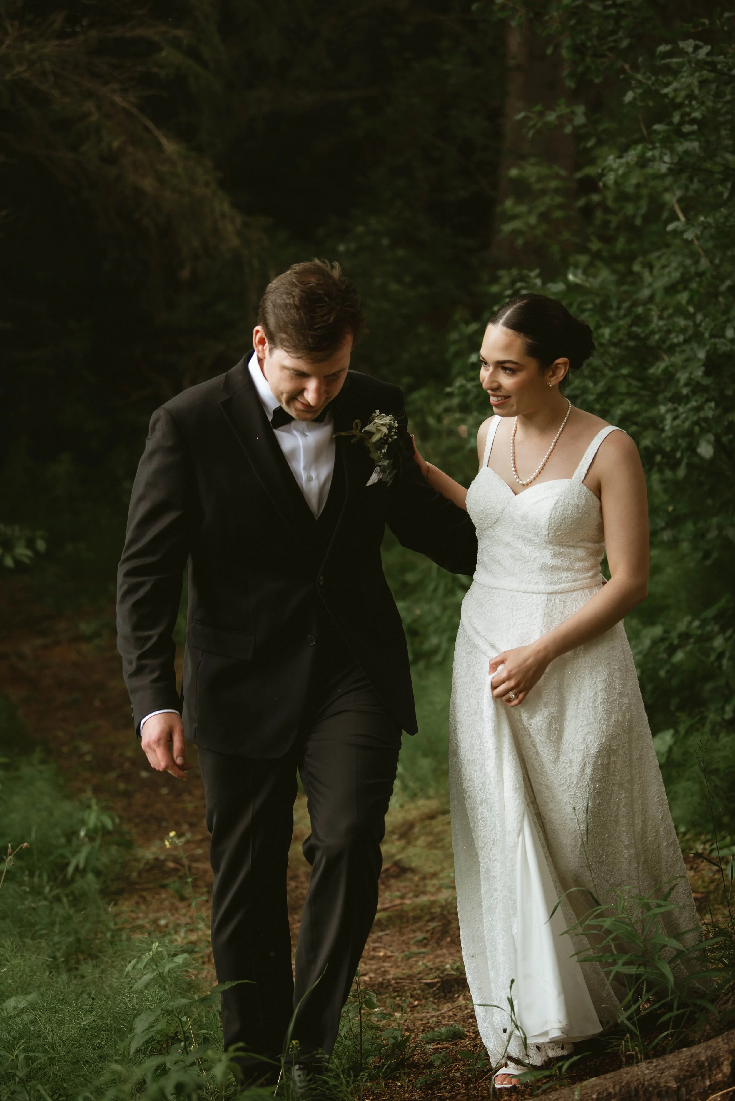 Bride and groom walking together outdoors during their wedding portraits in Central Alberta