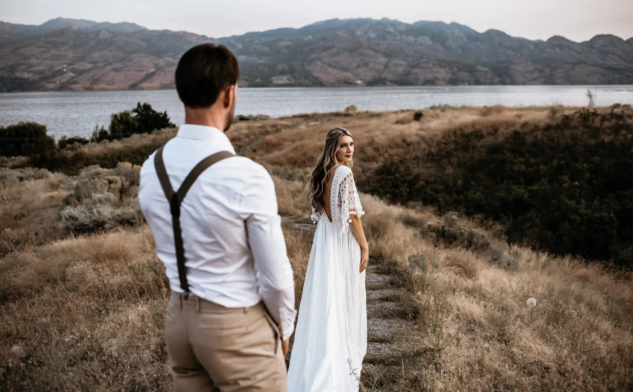 Bride and groom standing together on their wedding day in Kelowna BC taking portraits by Danielle Aichelle Photography