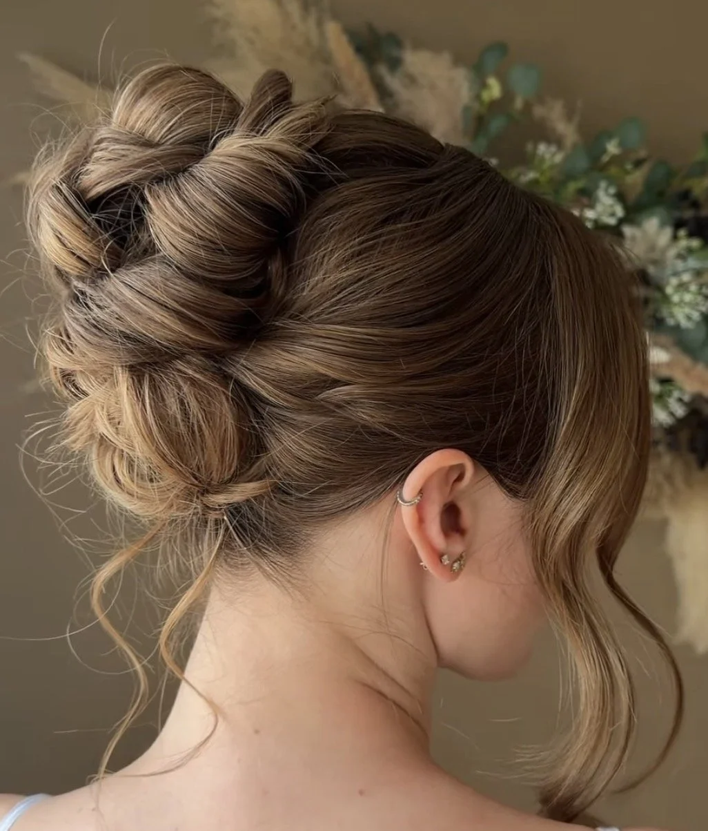 Back view of a romantic textured bridal updo with soft face framing curls, styled by Danielle Aichelle Artistry for a wedding at Hilltop Wedding Center in Sylvan Lake, Alberta