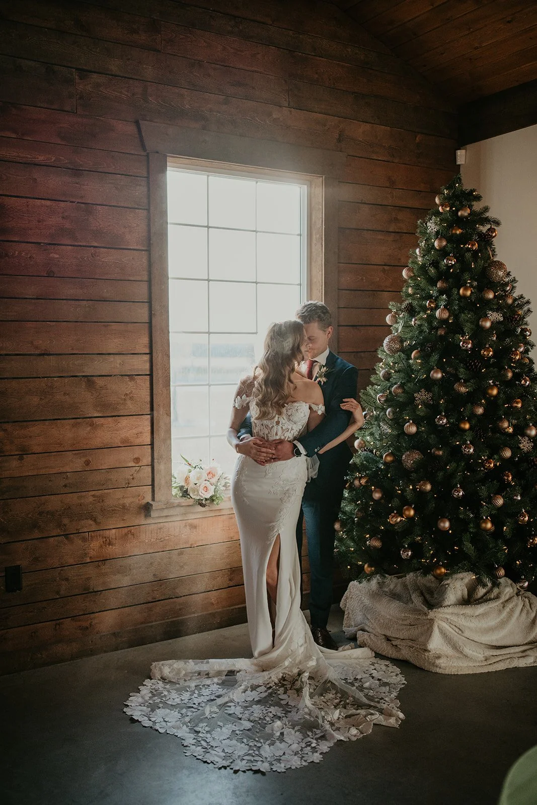 Bride and groom beside a Christmas tree at River Valley Wedding venue in Central Alberta