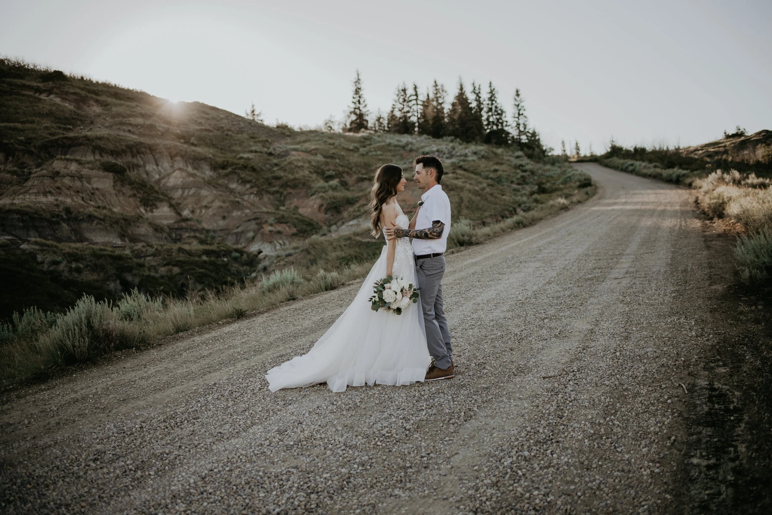 Bride and groom on a quiet gravel road during a Drumheller elopement