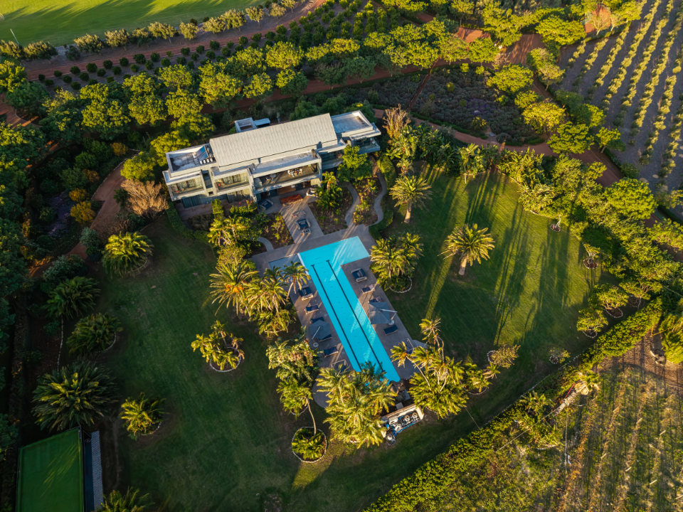 Ludus Magnus Manor House and swimming pool surrounded by the Franschhoek mountains and Winelands.