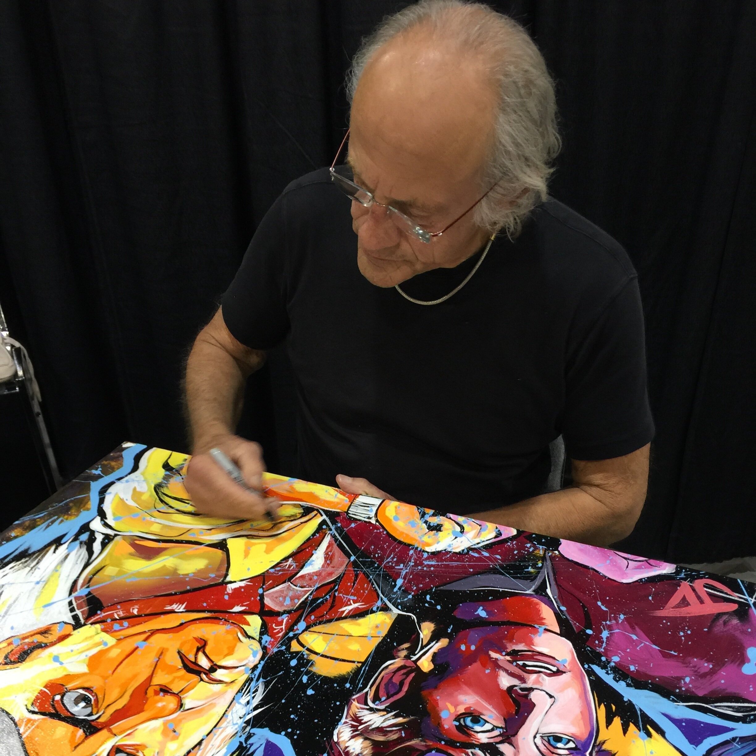 Christopher Lloyd signing an original painting by Jay Valentin