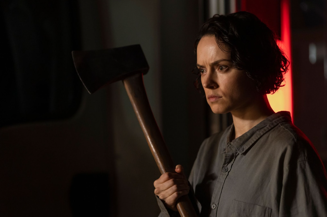 Woman holding axe in WE BURY THE DEAD (2025) horror film