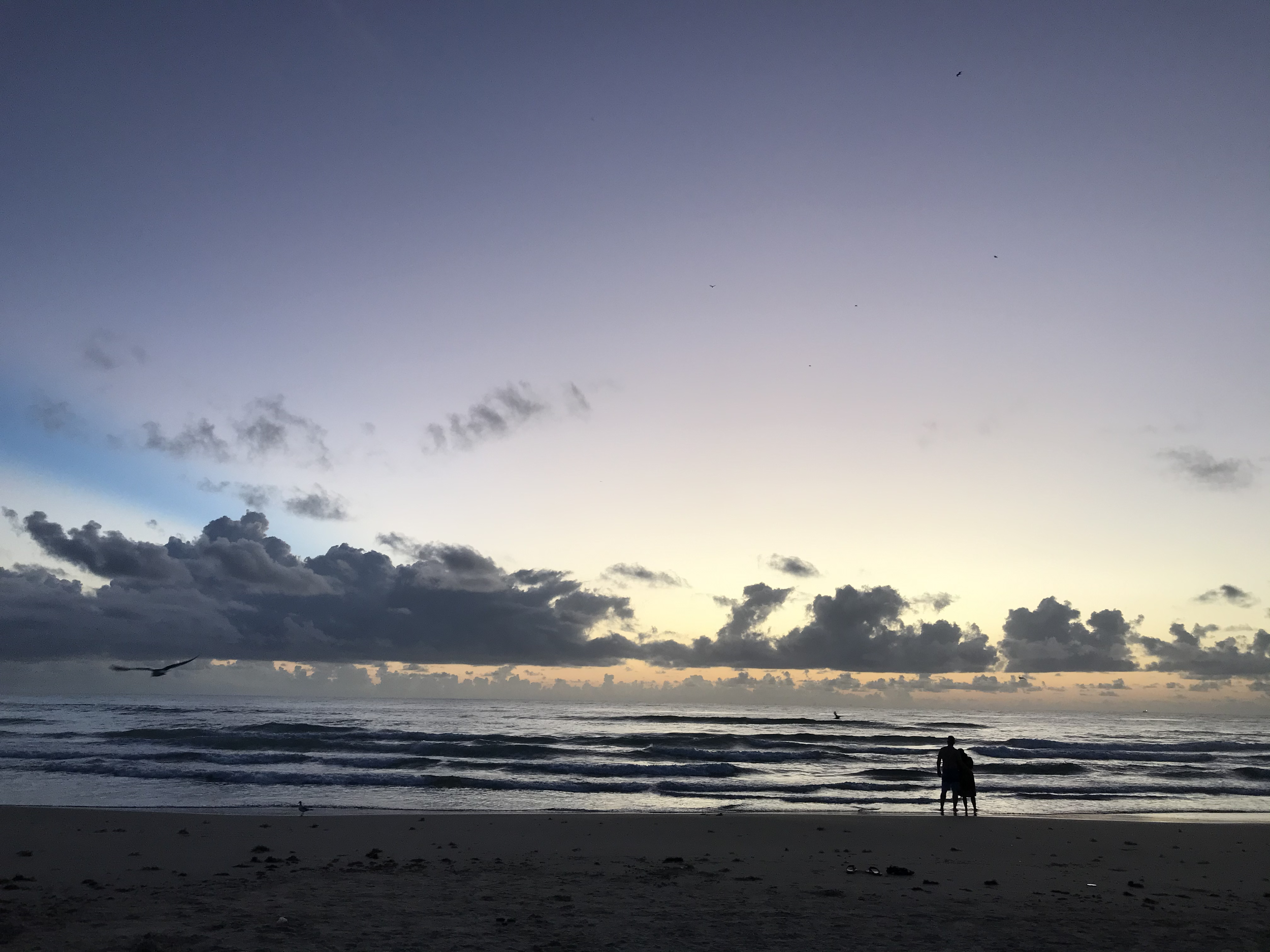 Couple watching the sunrise at South Padre Island, Texas.