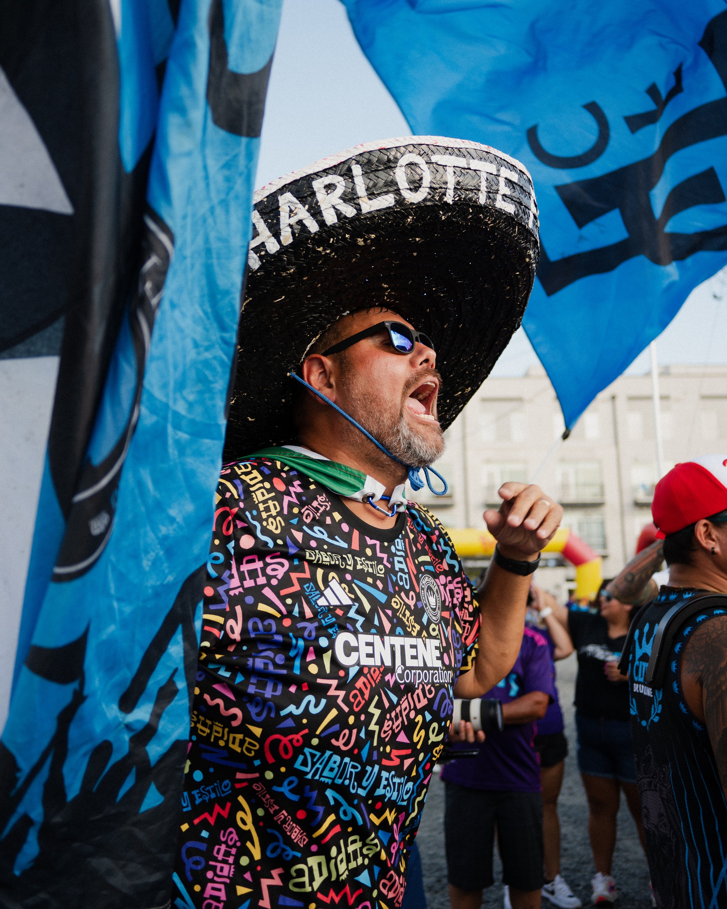 Hector – wearing his sombrero – sings at the tailgate surrounded by Charlotte FC flags.    
